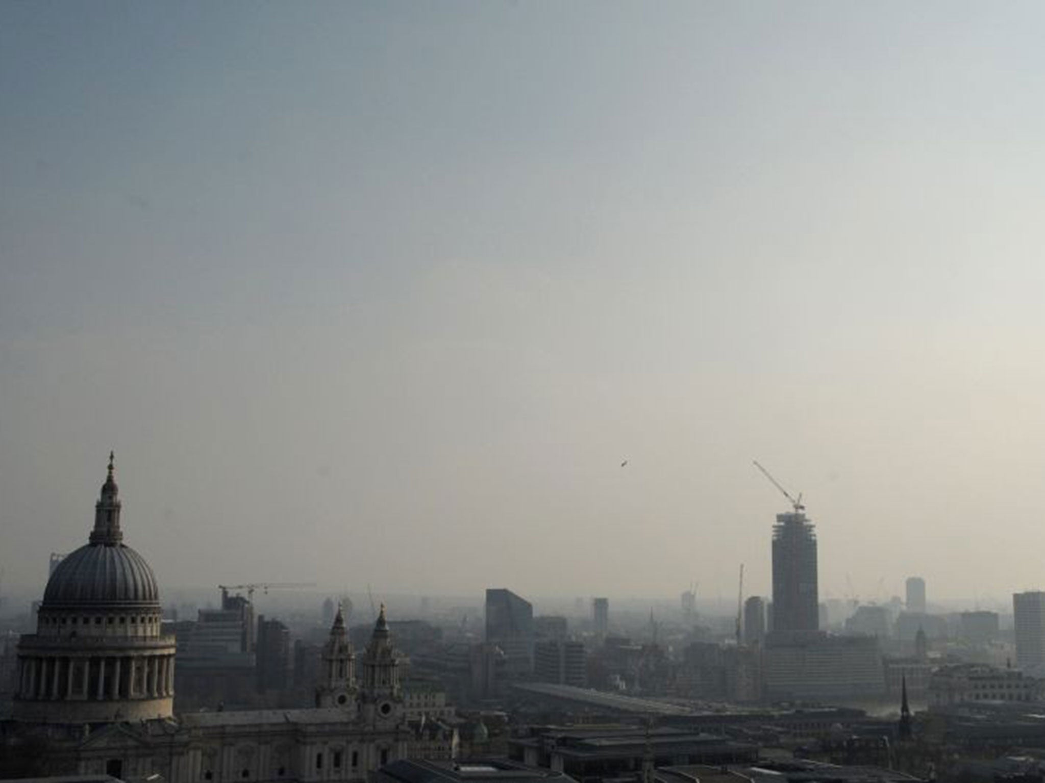 Air pollution obscures the view of the London eye with St Pauls in the foreground in central London
