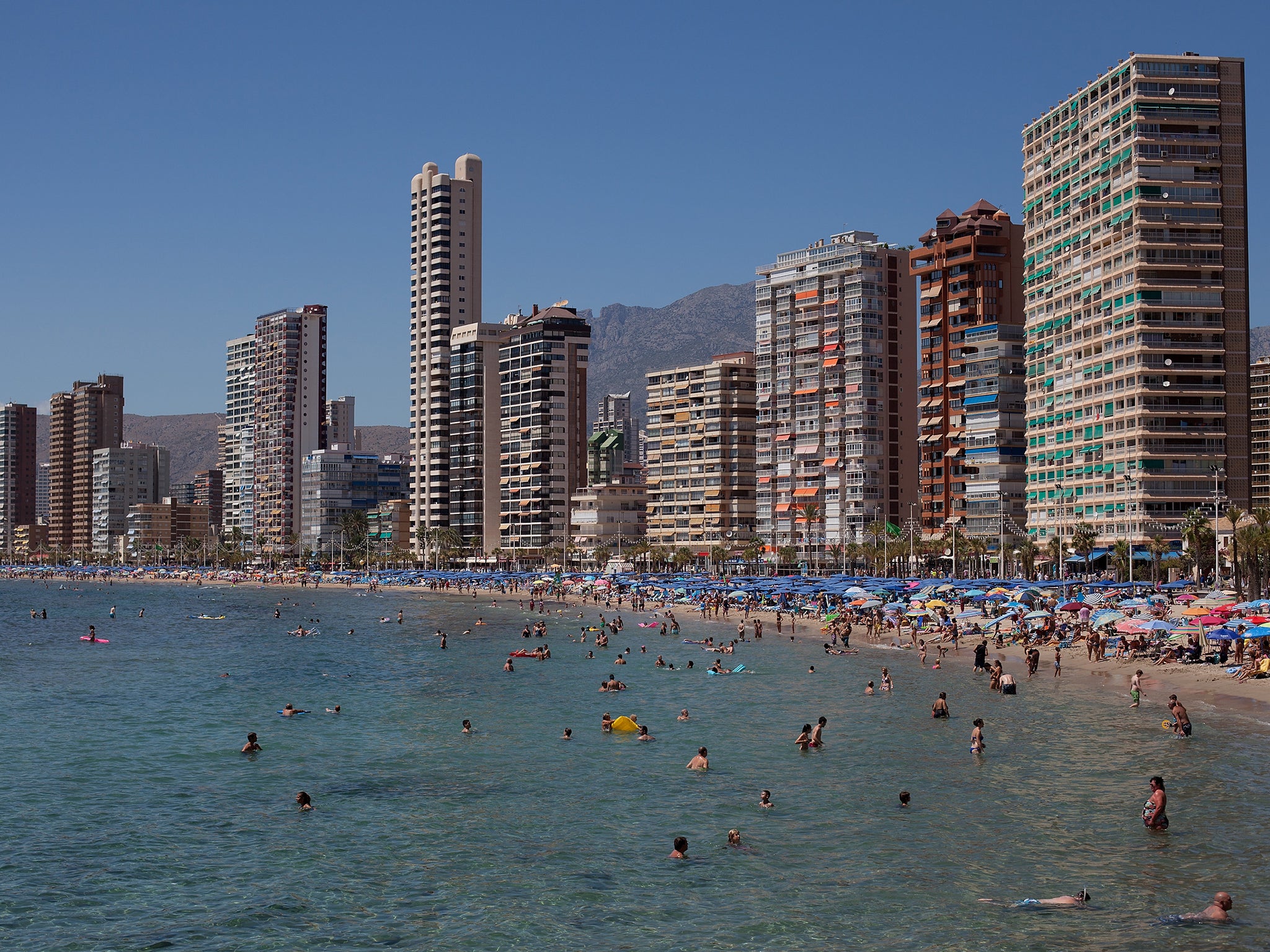 People enjoy the weather on Levante Beach in Benidorm, Spain