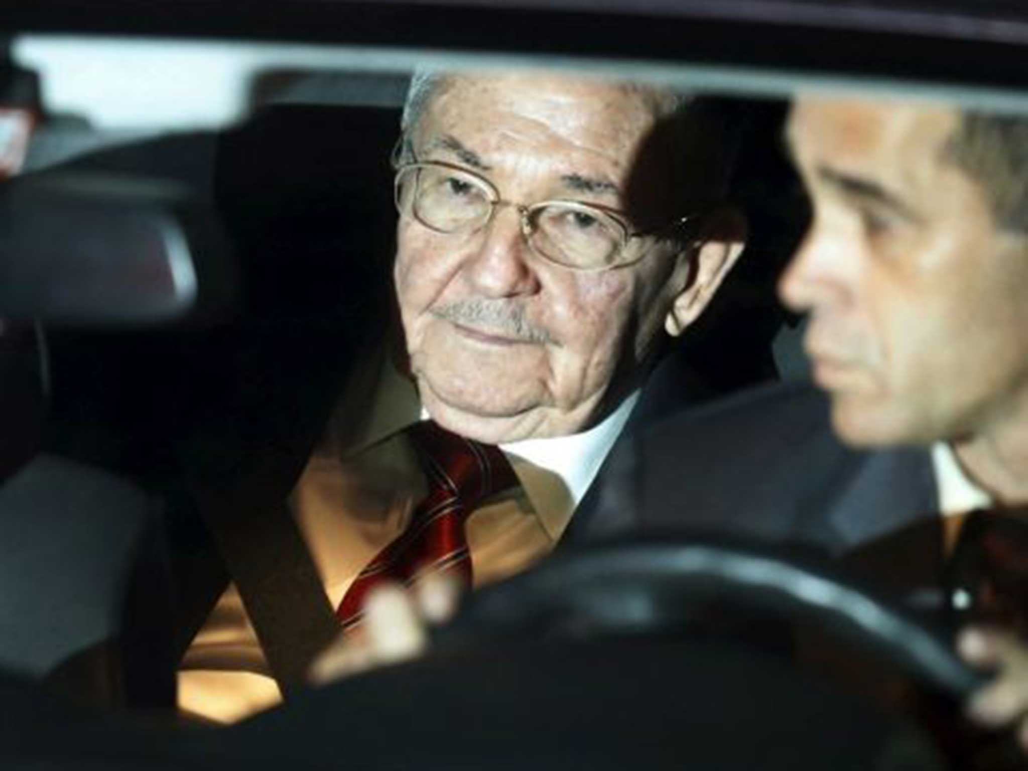 Cuba’s President Raul Castro (L) sits inside a car after arriving in Panama City