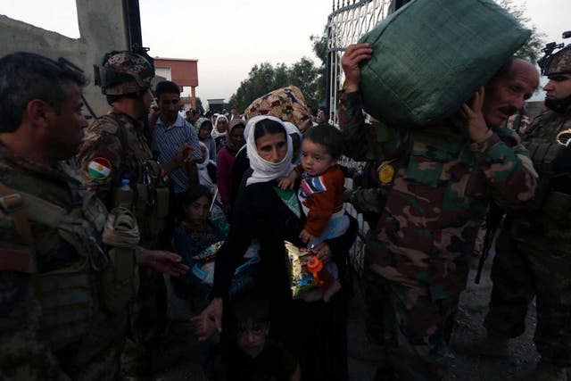Peshmerga forces help Yazidis freed by Isis in northern Iraq earlier this week 