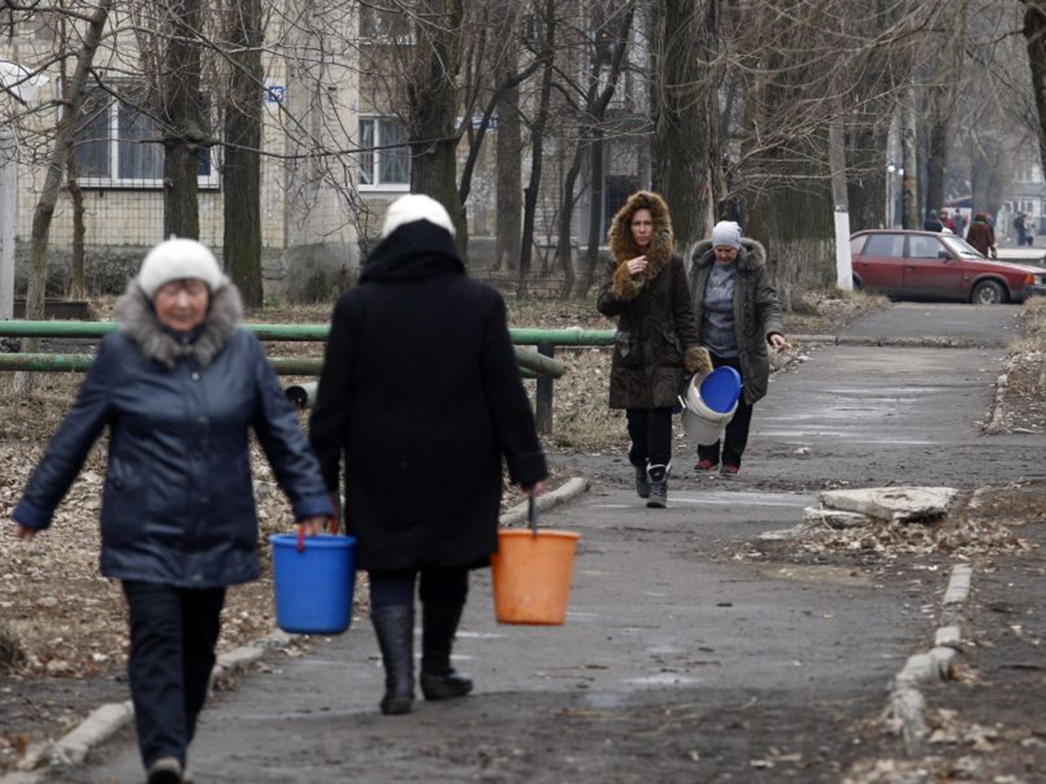 Residents walk to fill water containers from a tanker in Avdiivka; a huge number of Ukrainians have become refugees in their own country