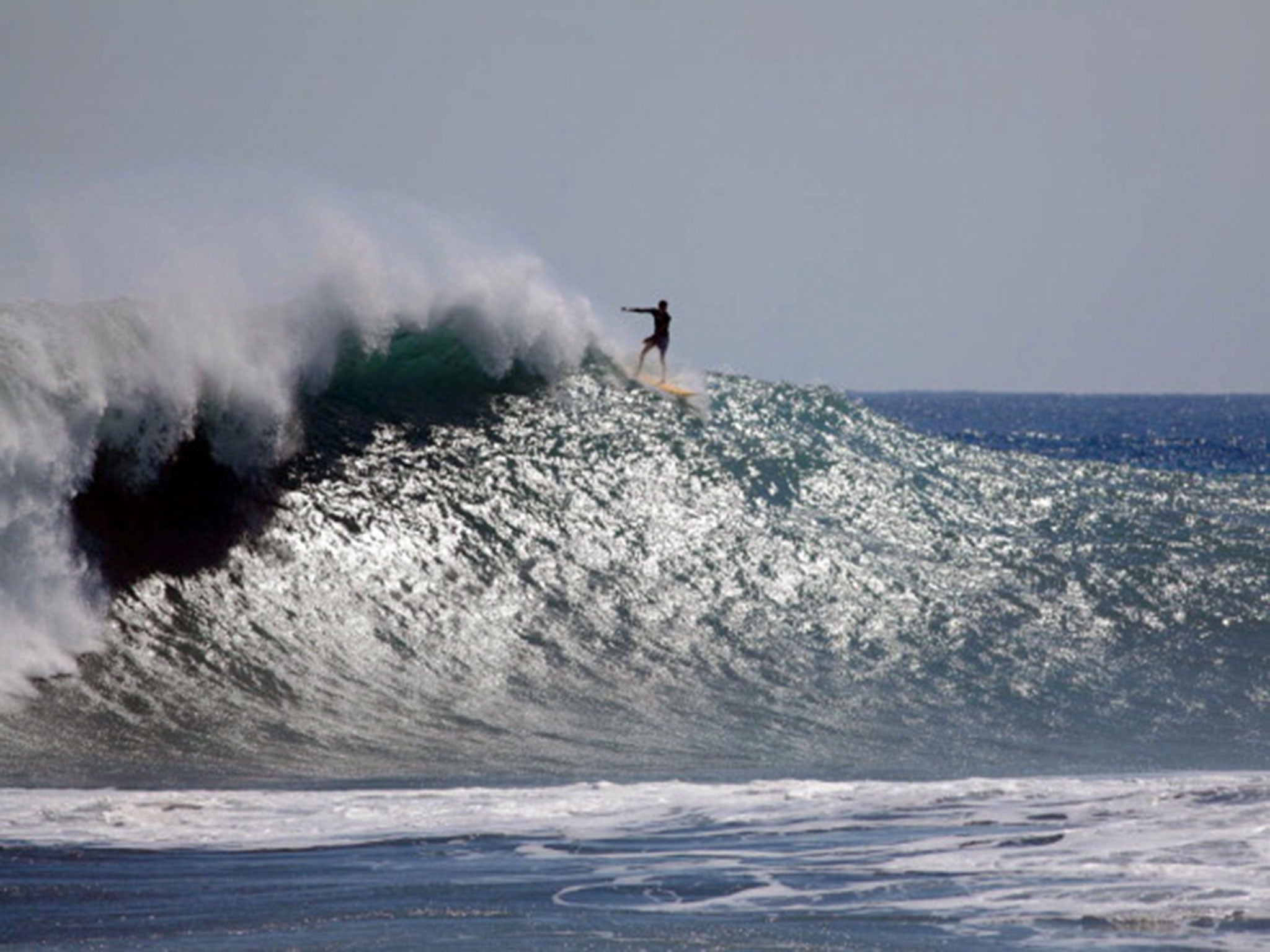 A surfer rides a wave off Reunion