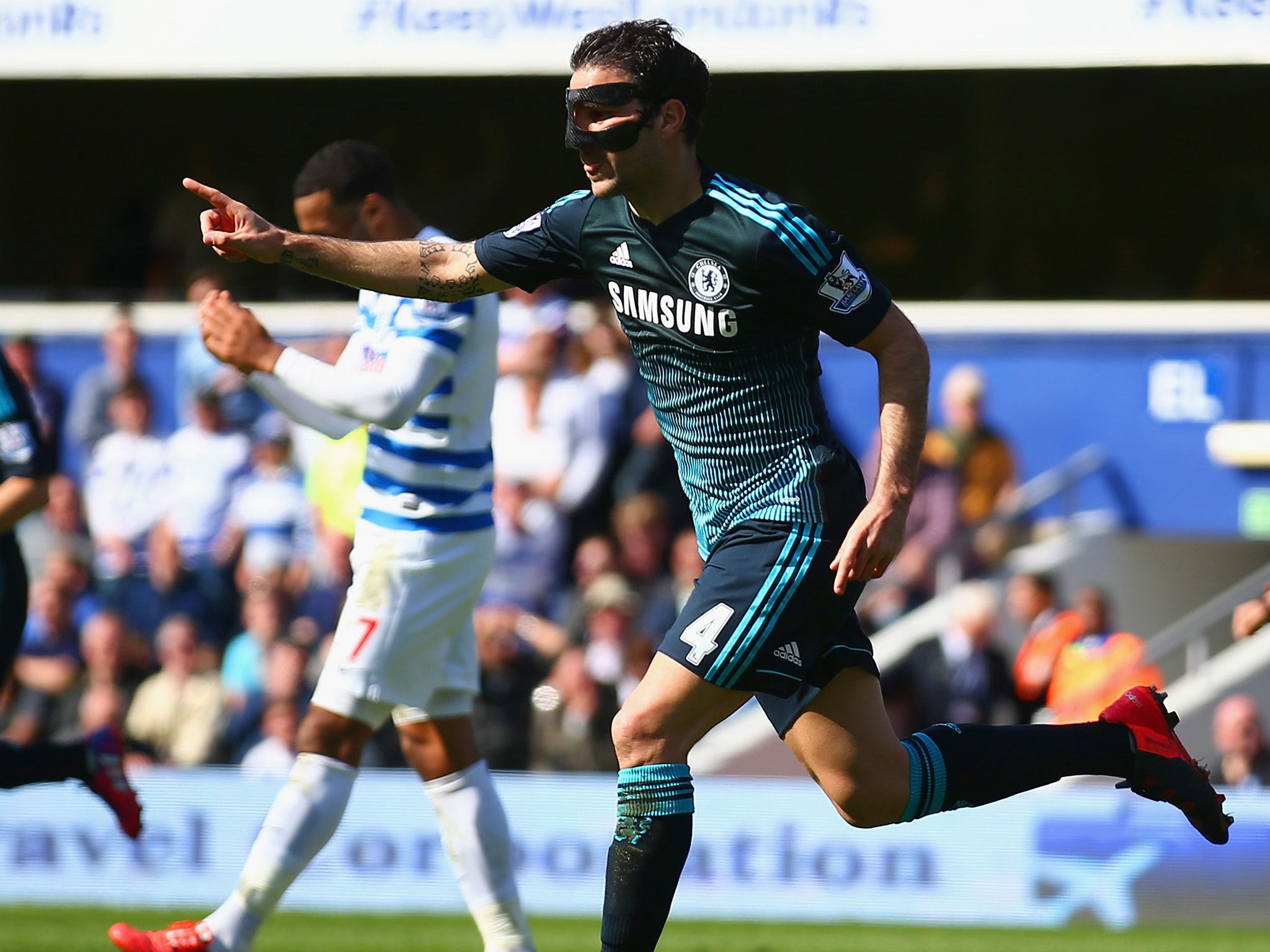 A masked Cesc Fabregas celebrates his crucial winning goal