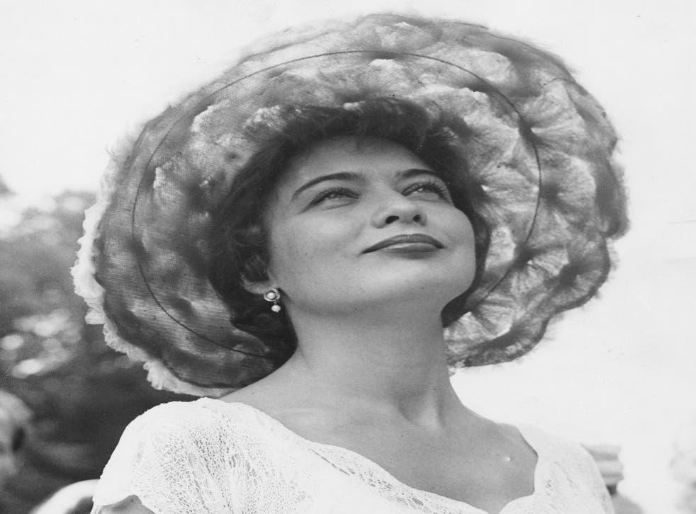 Portrait of actress and singer Julie Wilson, wearing a large tulle hat, at she attends Royal Ascot, England, June 18th 1958