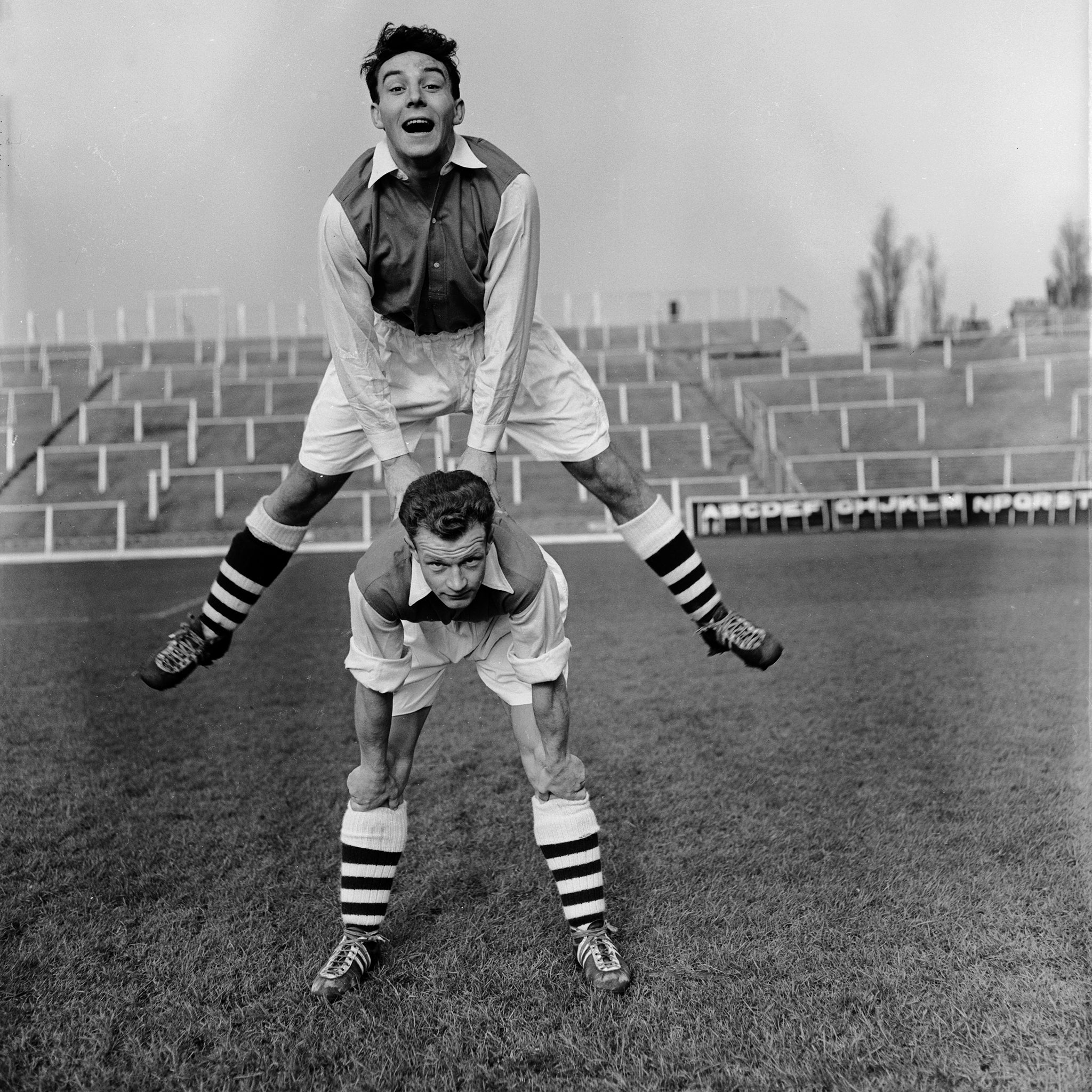 Arsenal's new signings from Leyton Orient, Vic Groves (jumping) and Stan Charlton, enjoying their first day of trraining at Arsenal's Highbury Stadium in North London in 1955.