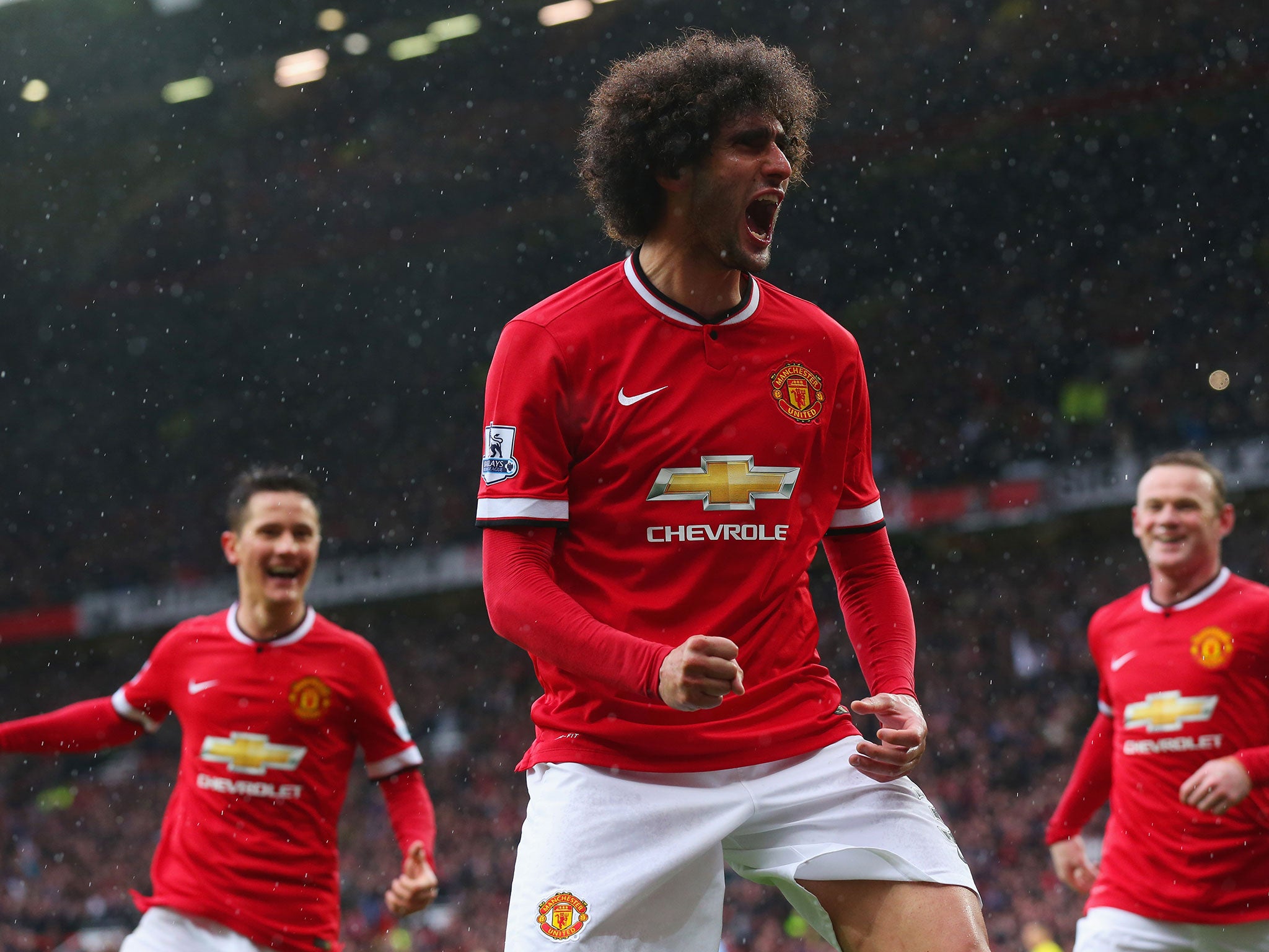 Marouane Fellaini celebrates after scoring United's second goal with a powerful header in their 4-2 win over City in the Manchester derby at Old Trafford