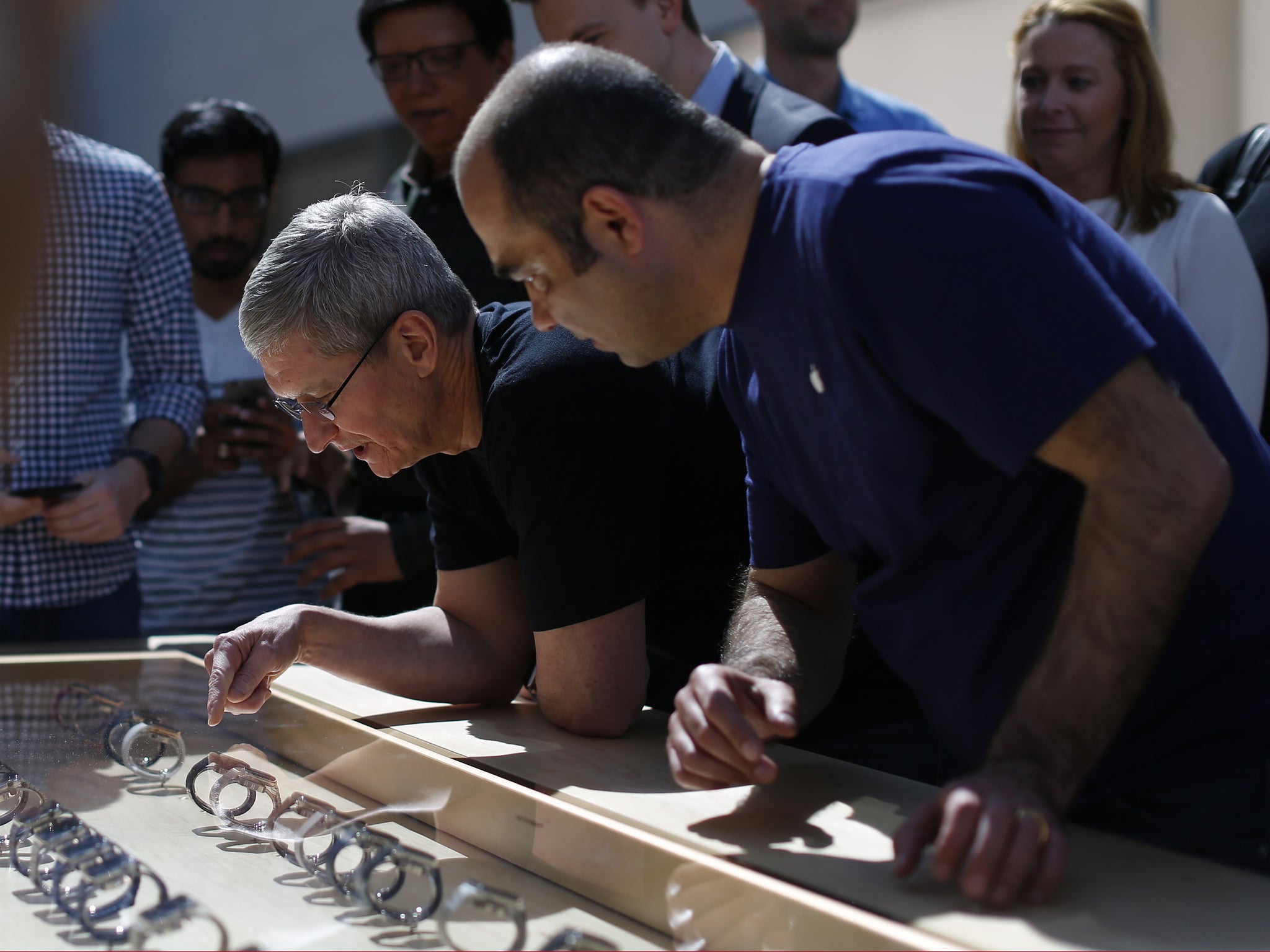Apple CEO Tim Cook points at an Apple Watch at an Apple Store on April 10, 2015 in Palo Alto, California. The pre-orders of the highly-anticipated wearable from the tech giant begin today as the watches arrive at stores for customers to preview.