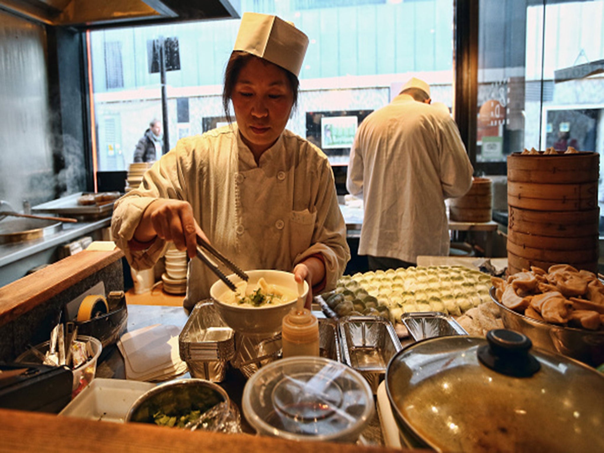 A chef prepares dumplings in a restaurant in China Town