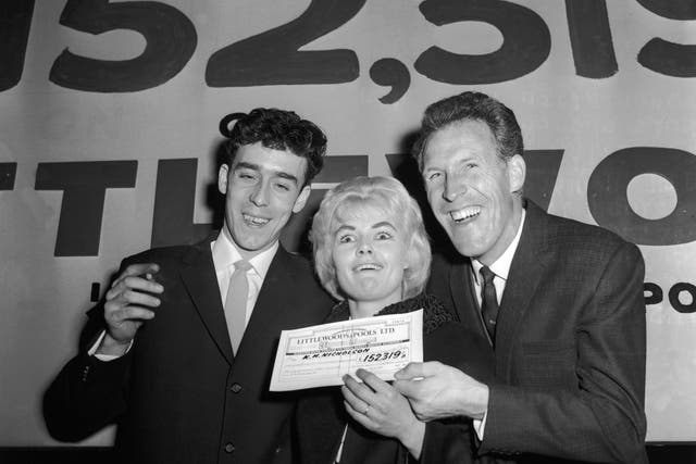 Bruce Forsyth, right, presents the winning pools cheque to Nicholson and her
husband Keith in 1961