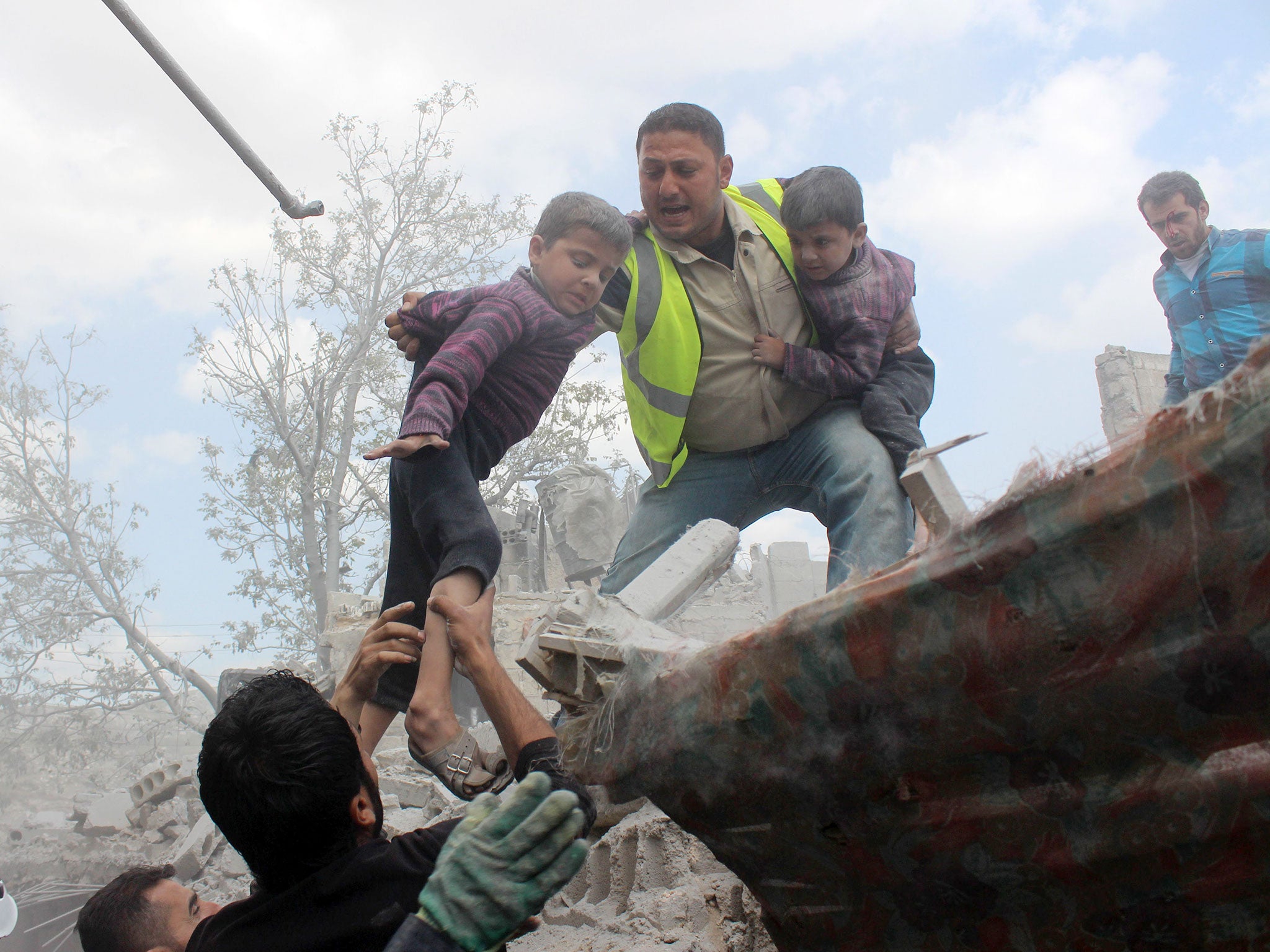 Syrian Civil Defence workers evacuate children from a building following a reported airstrike by government forces in a rebel held neighbourhood of the northern Syrian city of Aleppo