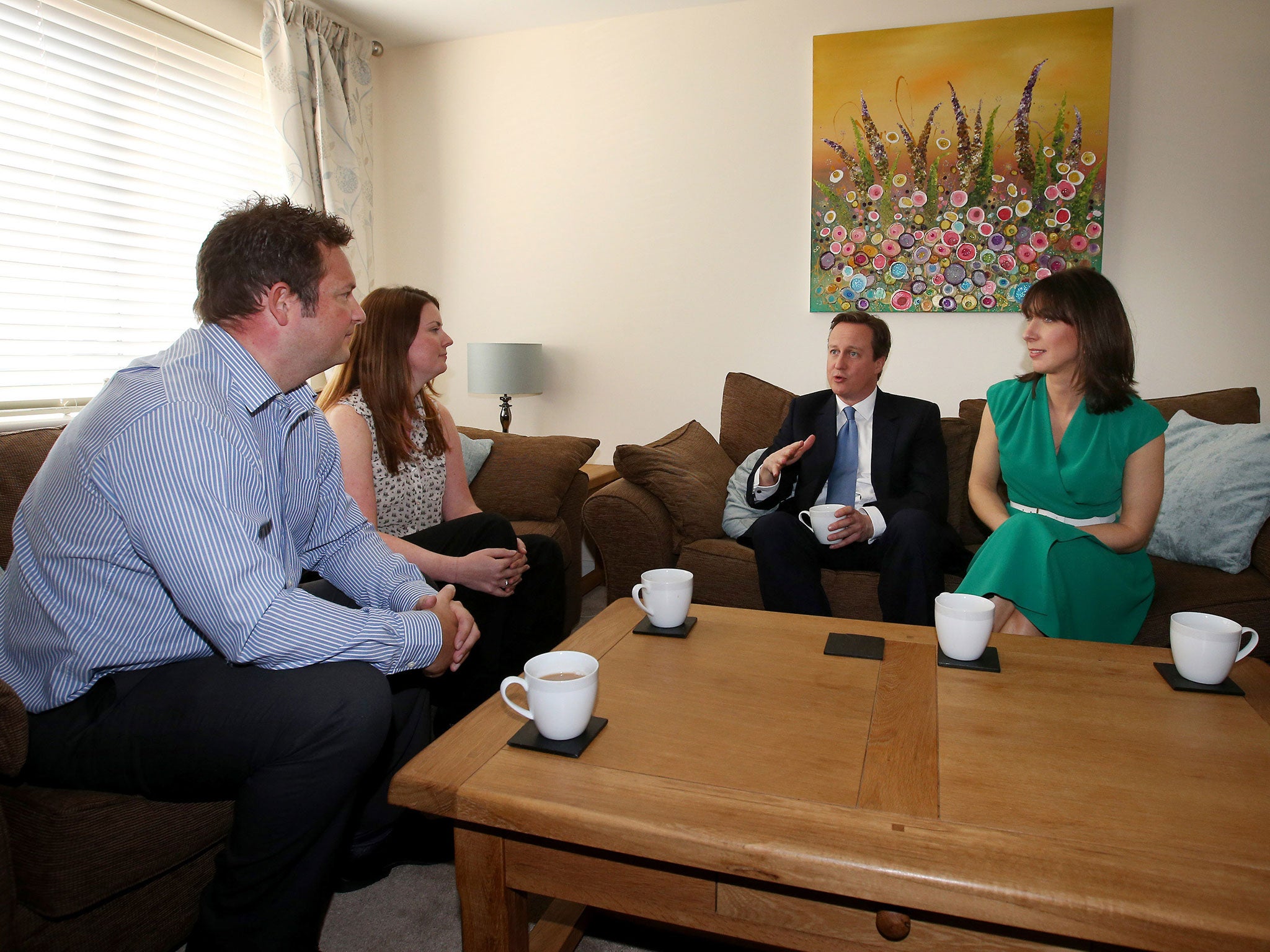 Prime Minister David Cameron and his wife Samantha meet Nicole Calver and Paul Pearson in their home in Swindon. The Conservatives have launched their election manifesto with a promise to extend the right to buy housing scheme for housing association tena