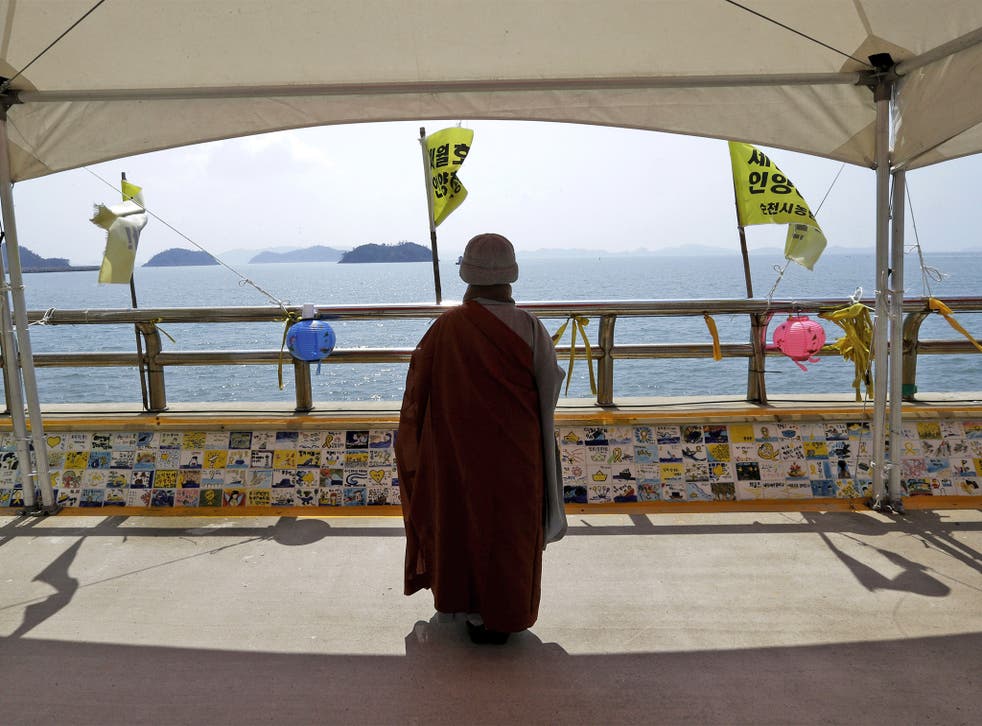 Buddhist monk prays for the victims of the ‘Sewol’ disaster at a port in Jindo, close to where the ferry sank a year ago