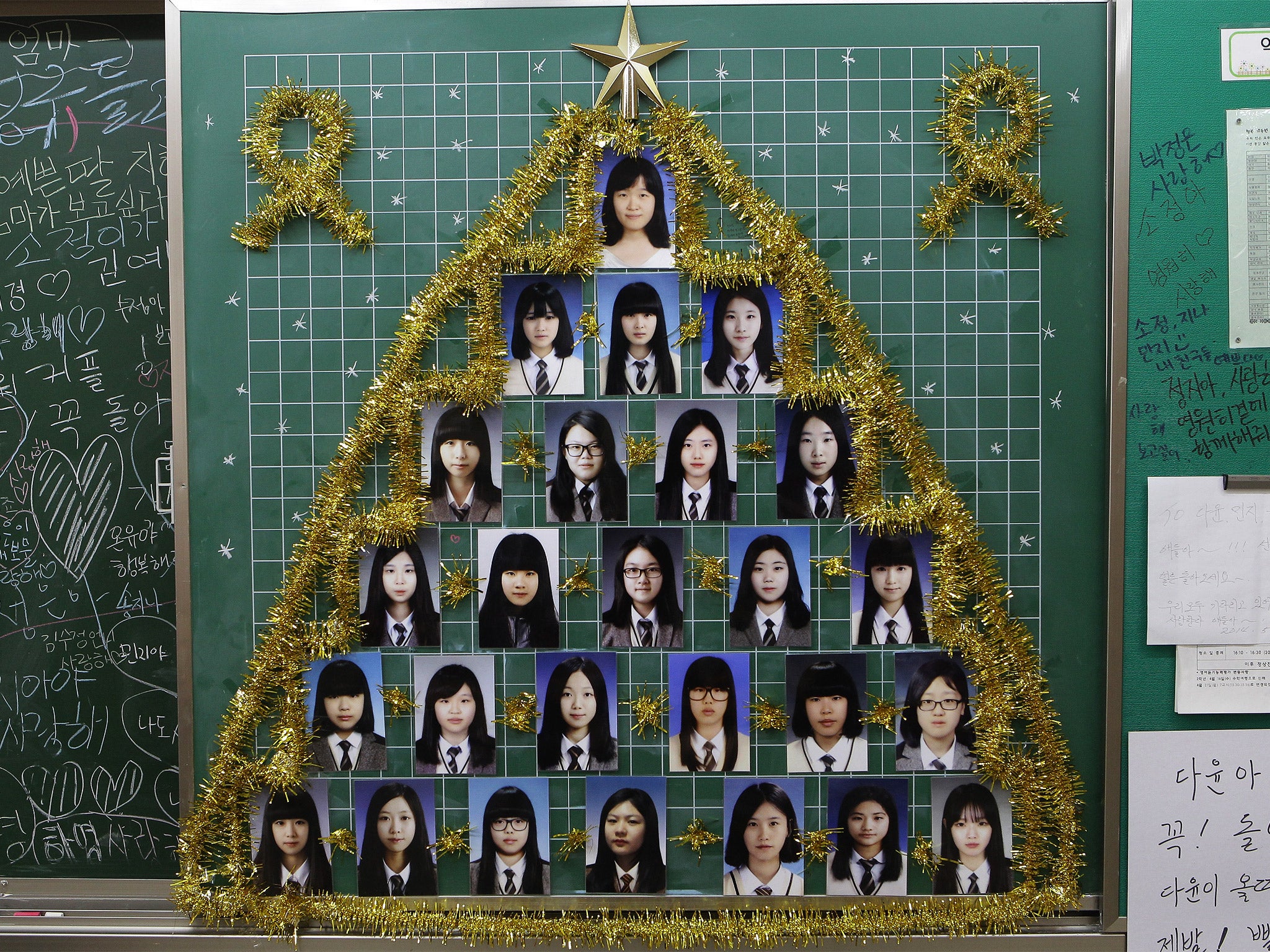 Photographs of Danwon High School students who were victims of the Sewol ferry disaster are displayed in a classroom at the school in Ansan, South Korea (Getty)