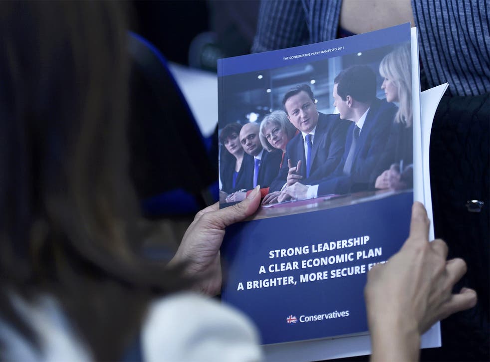 A woman reads the Conservative Party manifesto at its launch in Swindon