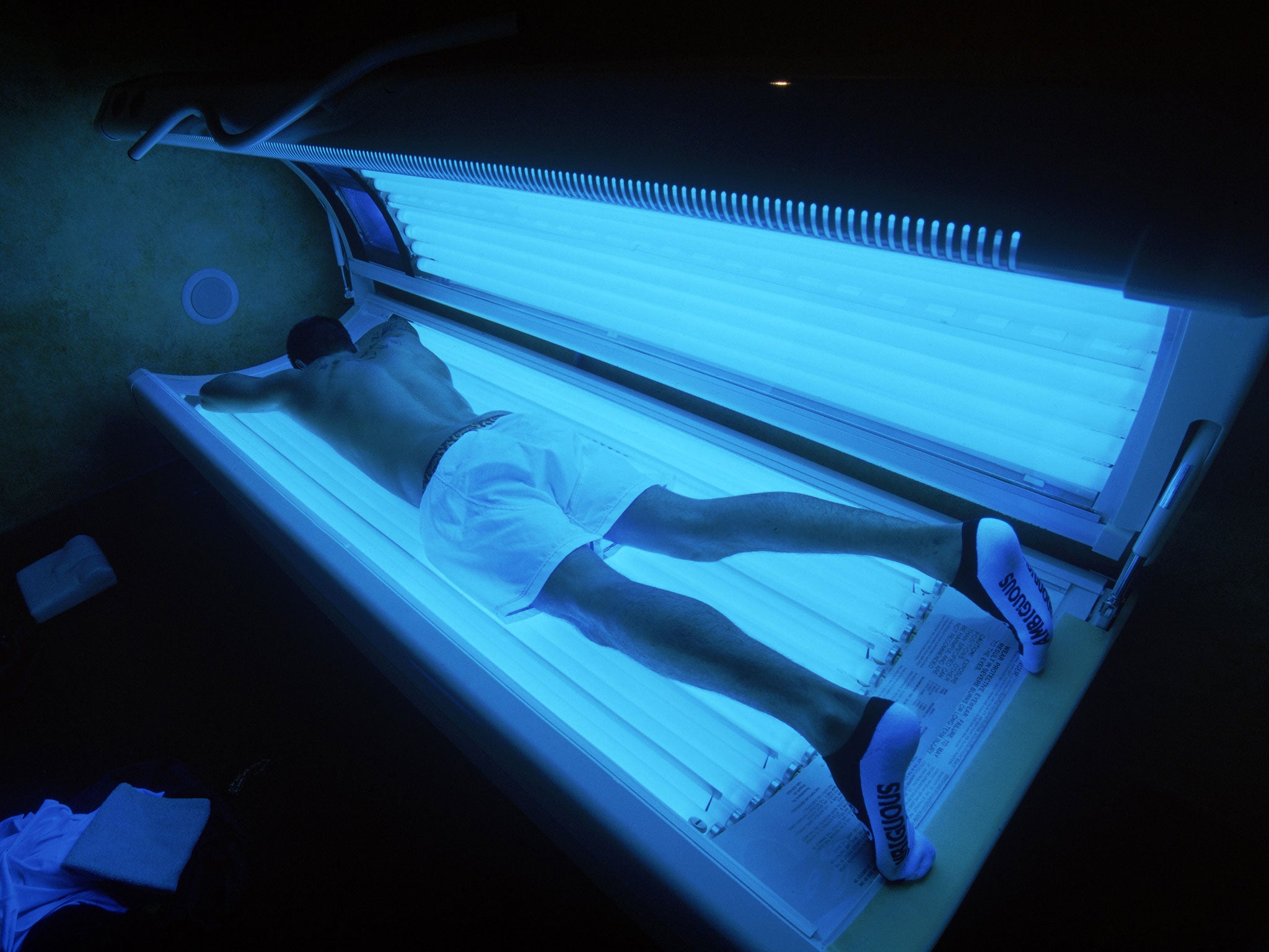 A man tans on a sun bed