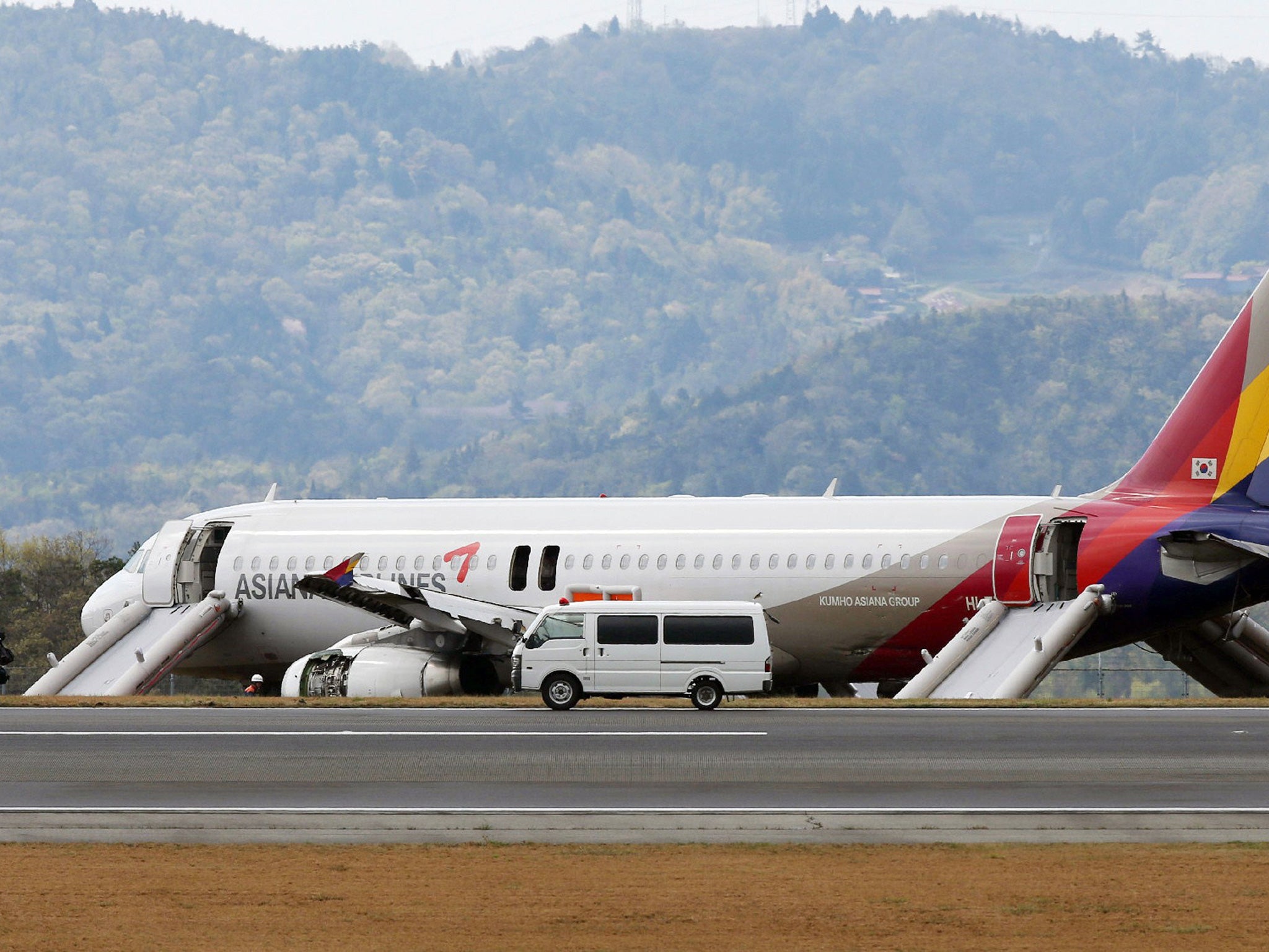 An Asiana Airlines Airbus A320 aircraft is seen with its evacuation slides deployed after it overran a runway at the Hiroshima airport in Mihara in Hirishima prefecture, western Japan on April 15, 2015.