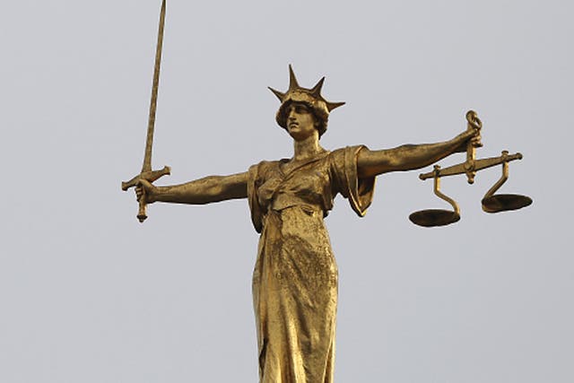 <p>A statue of the scales of justice stands above the Old Bailey</p>