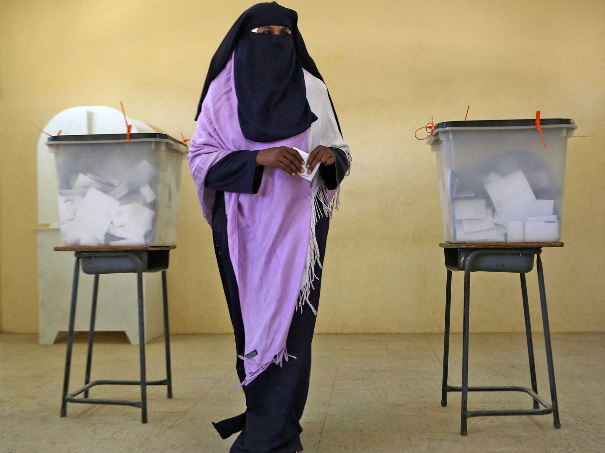 A Sudanese woman prepares to cast her vote at a polling station in Khartoum; one district of the capital had a 3 per cent turnout of registered voters