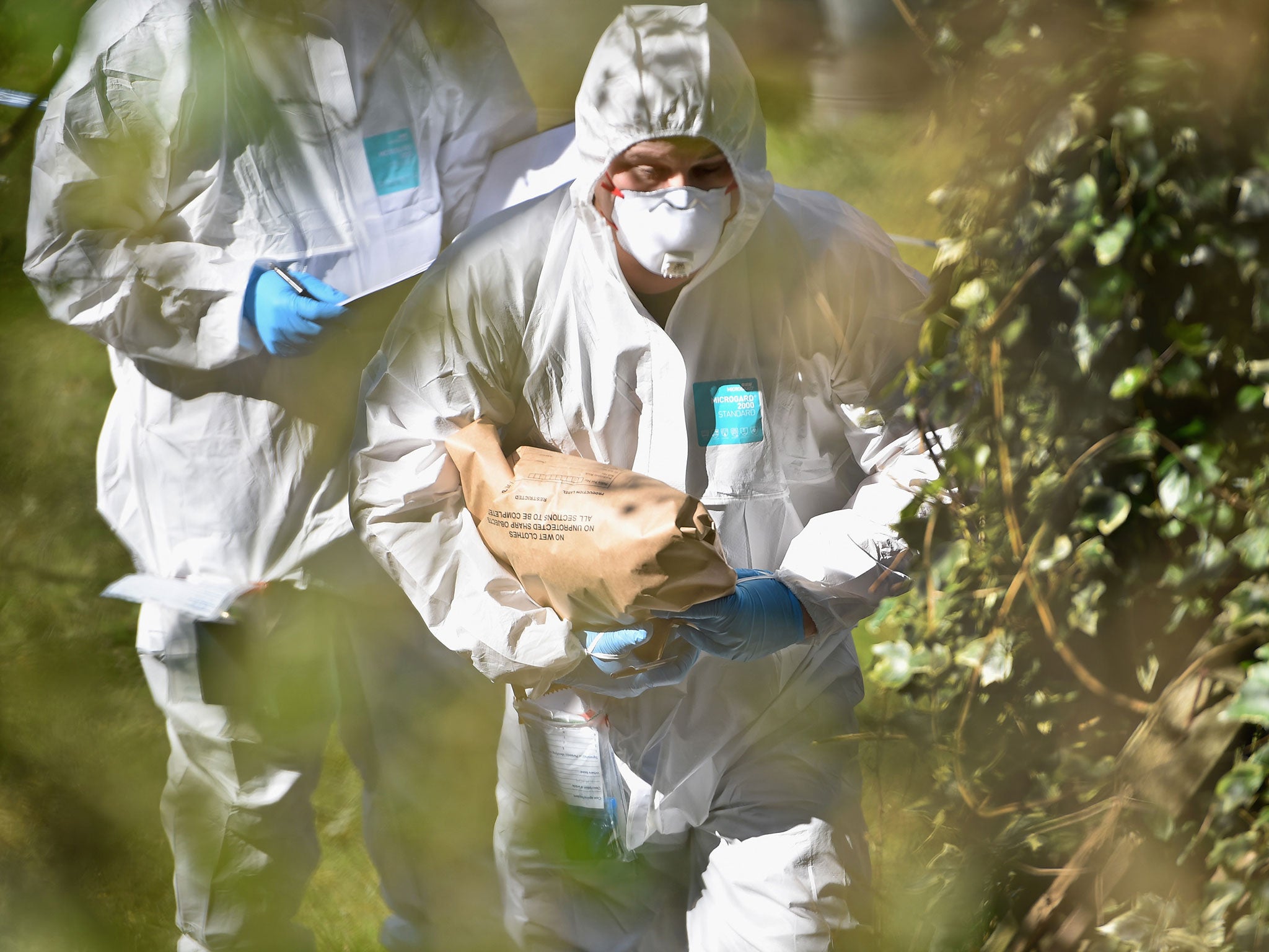 Police forensic officers searching a garden during the investigation