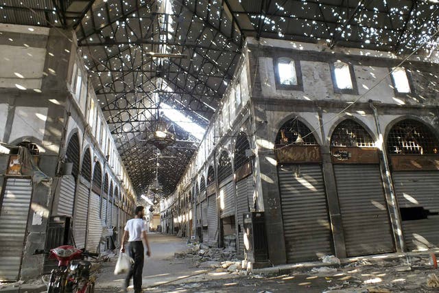A man walks in the bullet-riddled souk of Homs