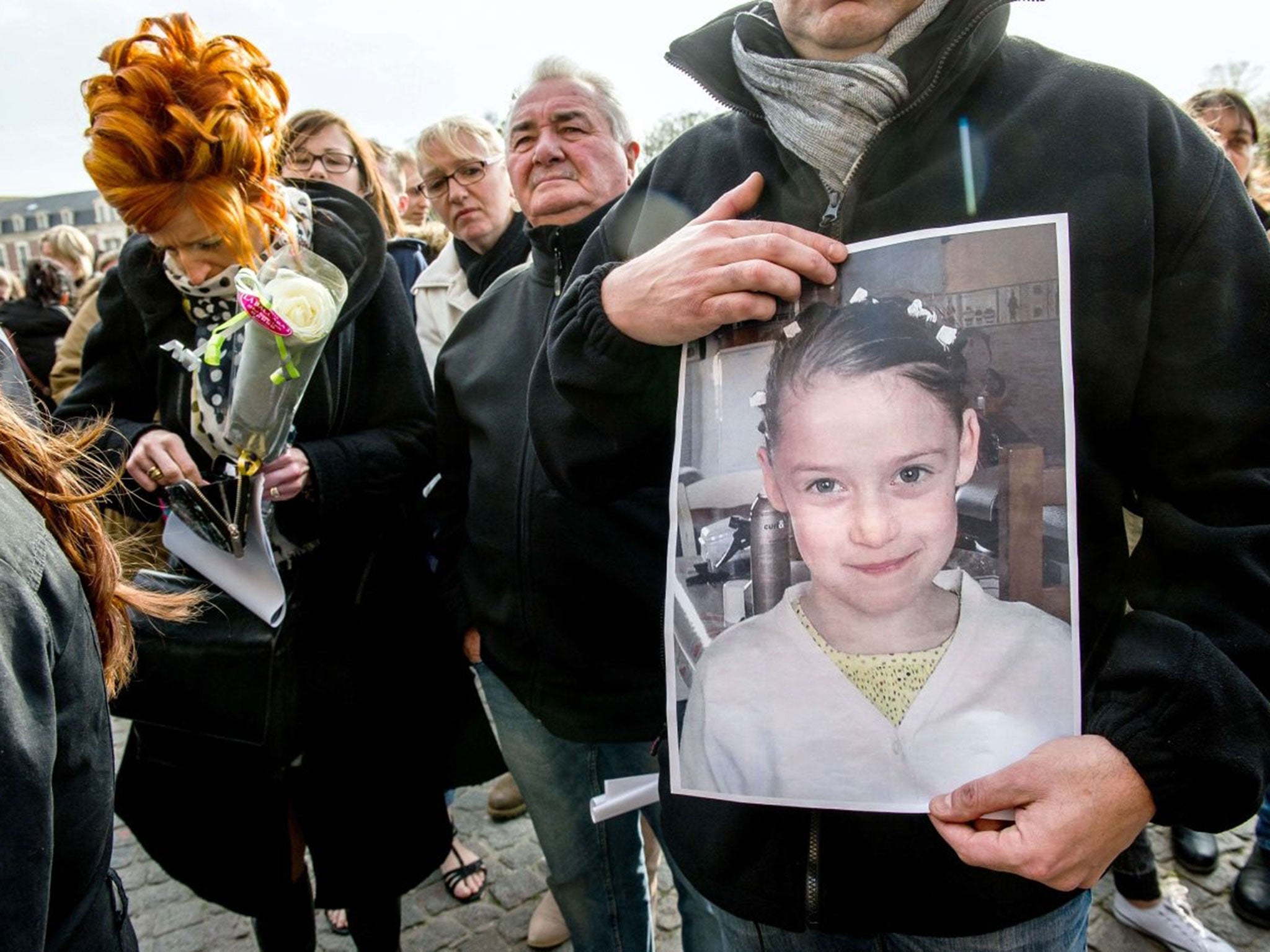 A person holds a portrait during a march on April 16, 2015 in Calais, northern France, in homage to a nine-year-old girl who was killed a day before.