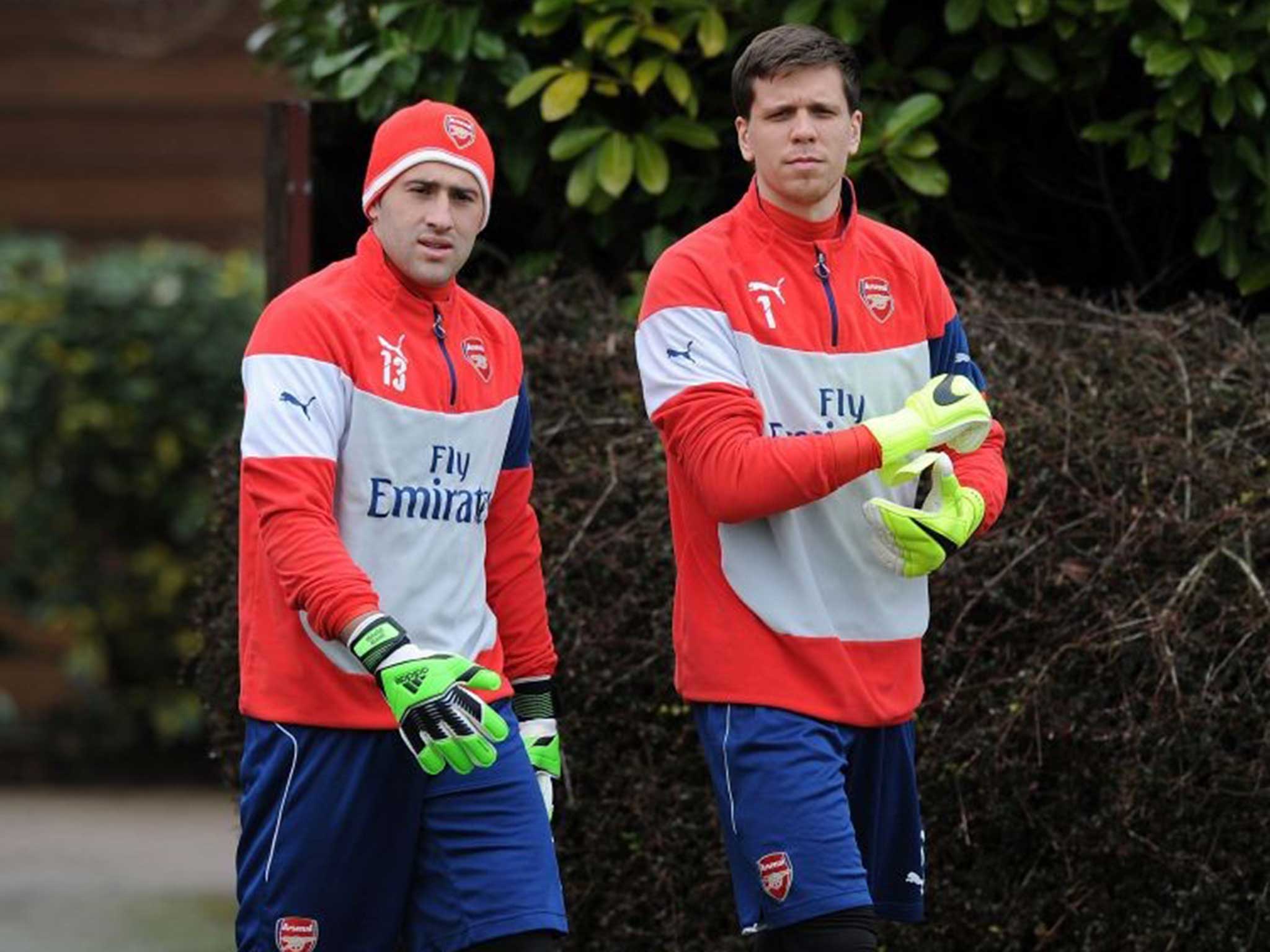 Wojciech Szczesny (right) and David Ospina head for Arsenal training at London Colney