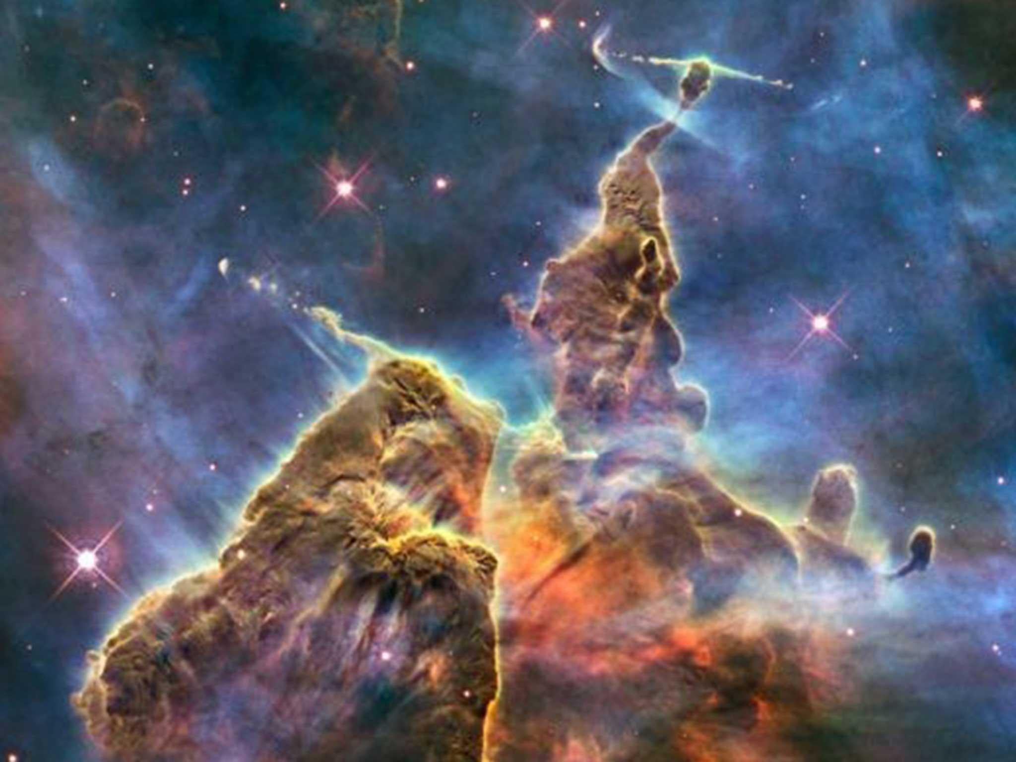 A Hubble image of a pillar of gas and dust that is being eaten away by the light from nearby stars in the Carina nebula, located 7,500 light years away