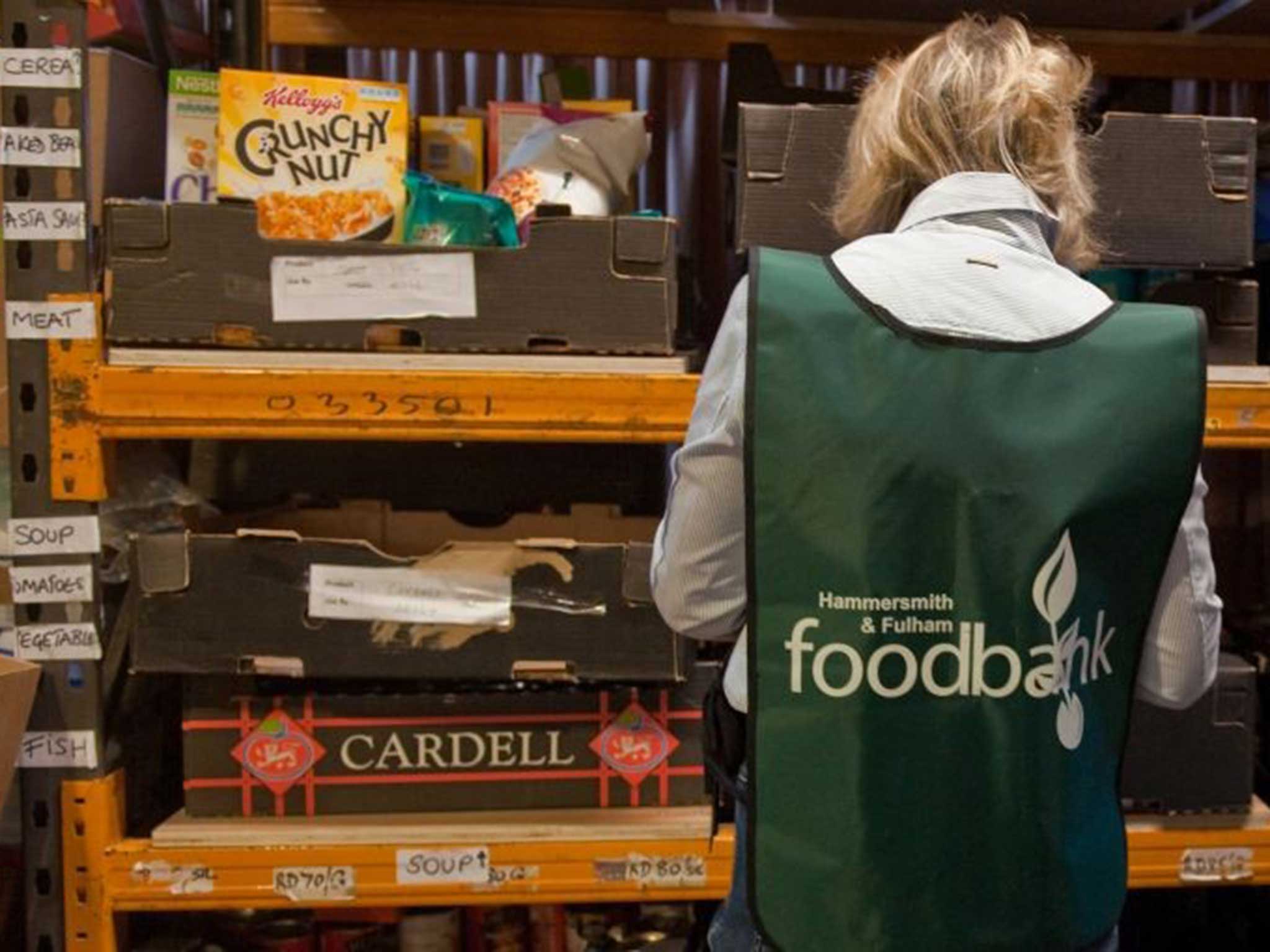 A volunteers sorts through donations of food at the Hammersmith and Fulham food bank run by the Trussell Trust in London