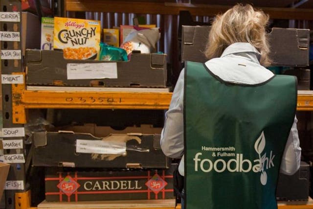 A volunteers sorts through donations of food at the Hammersmith and Fulham food bank run by the Trussell Trust in London