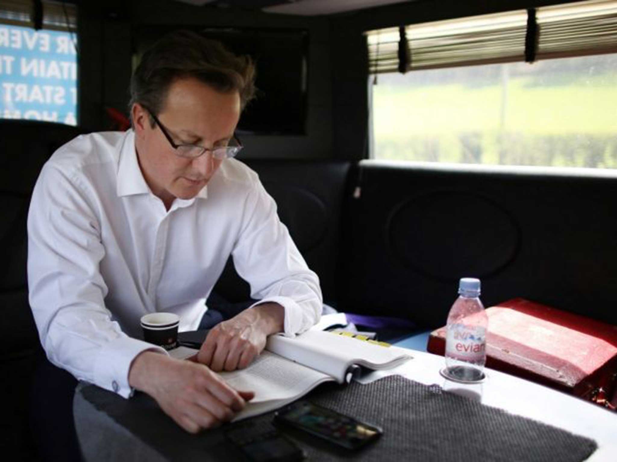 David Cameron works on a speech as the Conservative election campaign bus heads to Wales