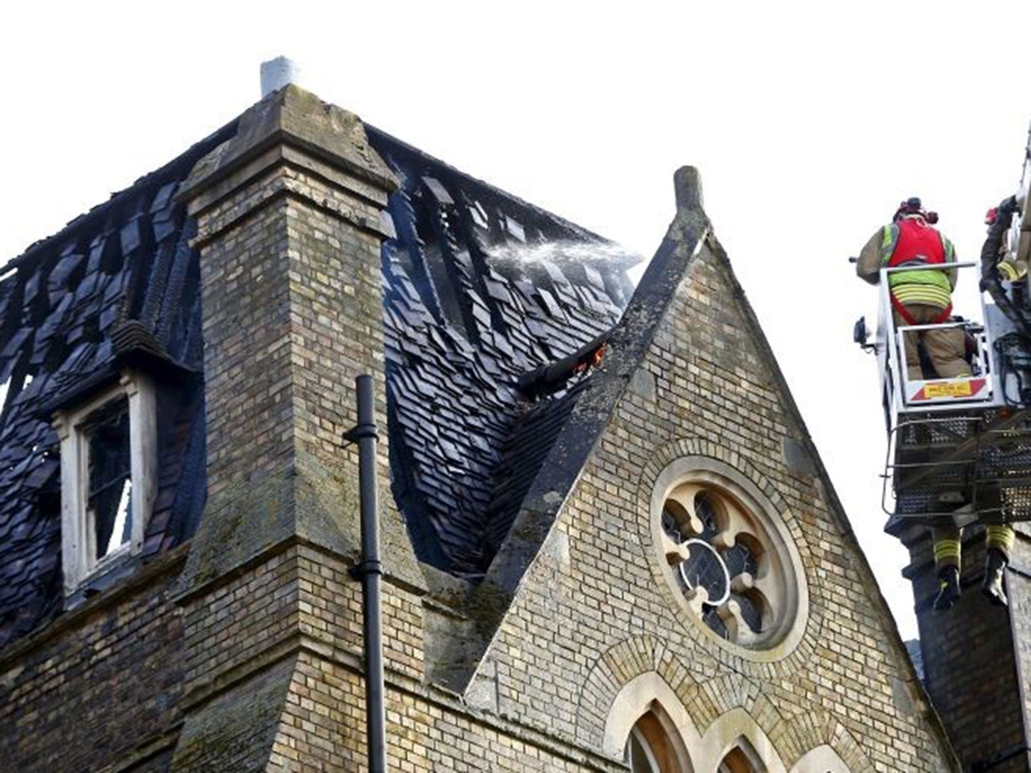 Firefighters dousing the damaged roof of the Randolph Hotel in Oxford on Friday