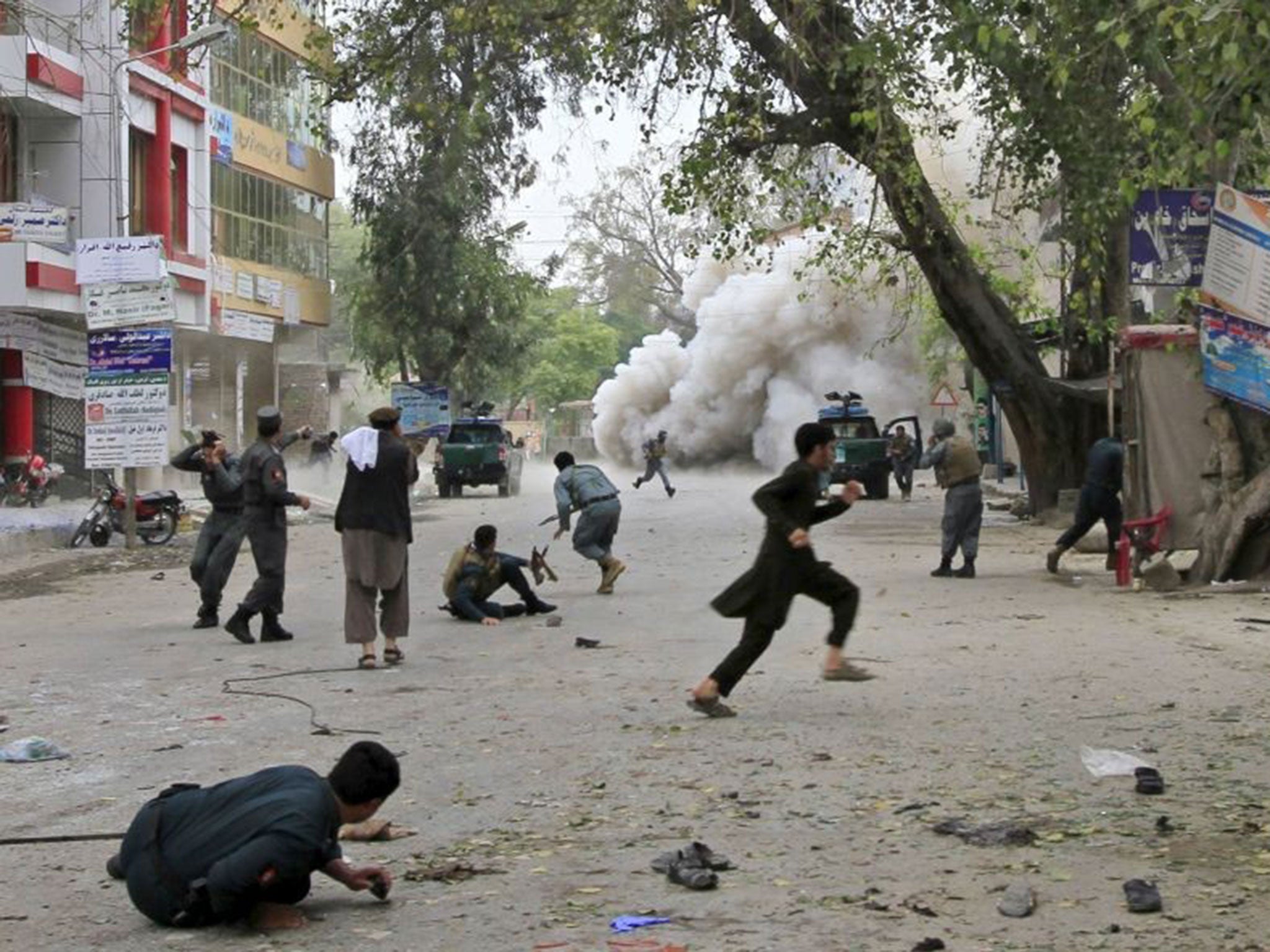 People run for cover after an explosion in Jalalabad on April 18, 2015
