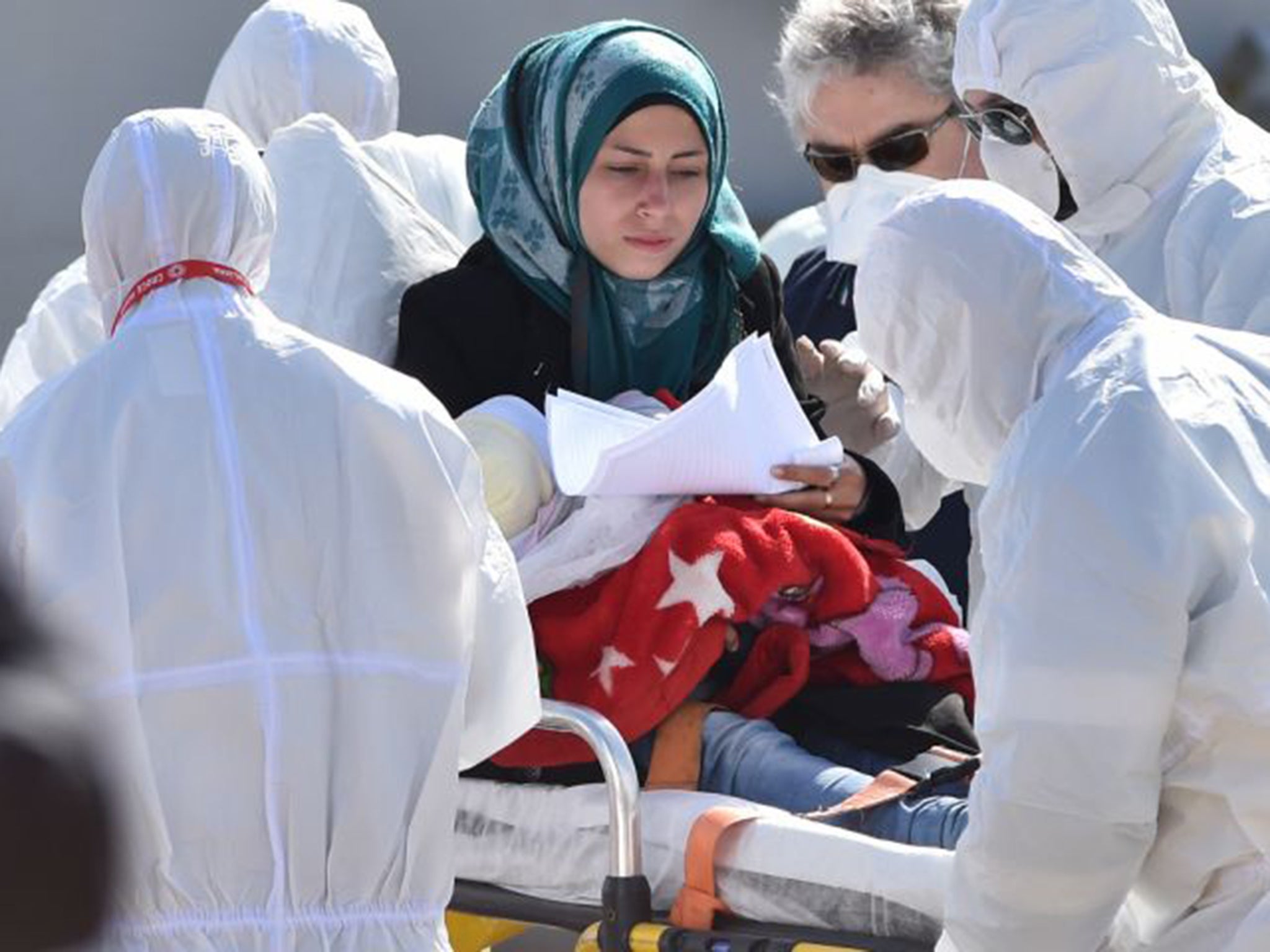 A mother and child receive first aid as they disembark in Italy on Saturday