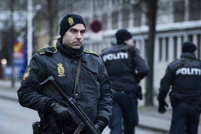 A police officer guards the street around the Noerrebro train station in Copenhagen on February 15, 2015 after a man has been shot in a police action following two fatal attacks in the Danish capital