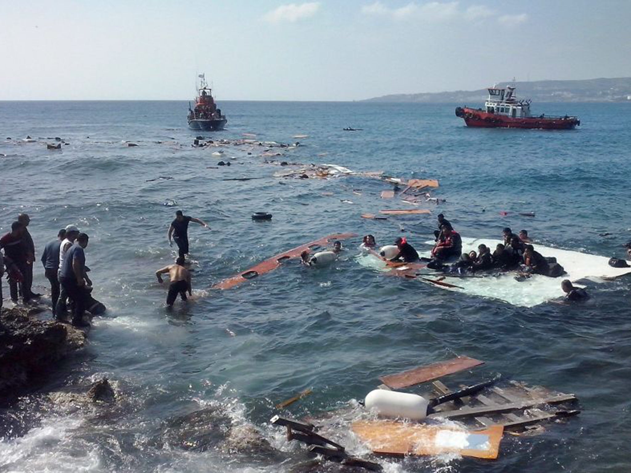 Survivors cling on to debris after the boat they were in ran aground at Zefyros beach in Rhodes on Monday