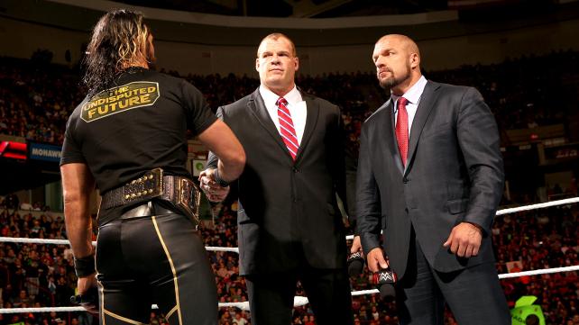 Rollins and Kane shake hands under the watchful eye of Triple H