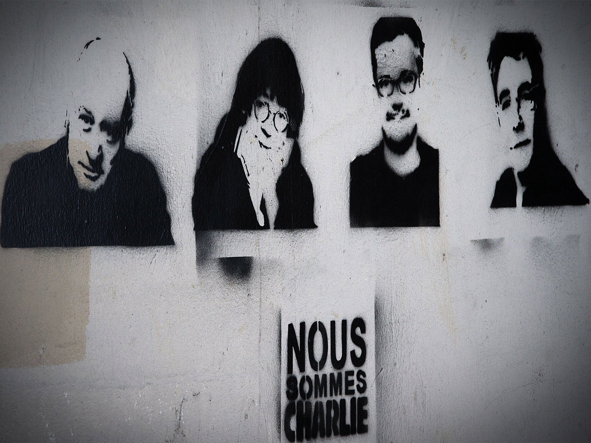 Stencil graffiti depicting slain cartoonists, from left; Wolinski, Cabu, Charb and Tignous, on a wall near the Paris headquarters of 'Charlie Hebdo' (Getty)