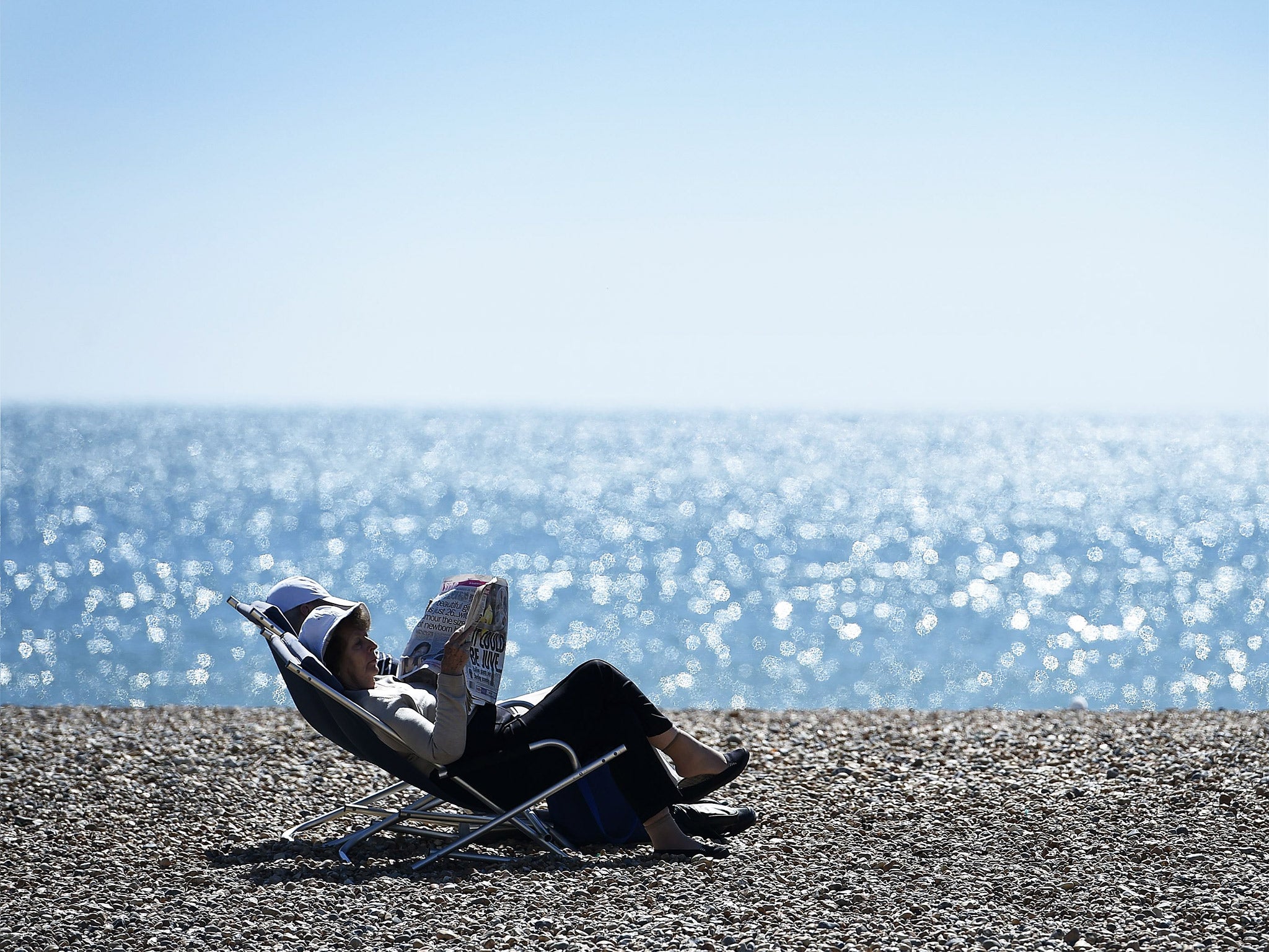 A couple sit on Brighton beach on Tuesday during unseasonably hot weather