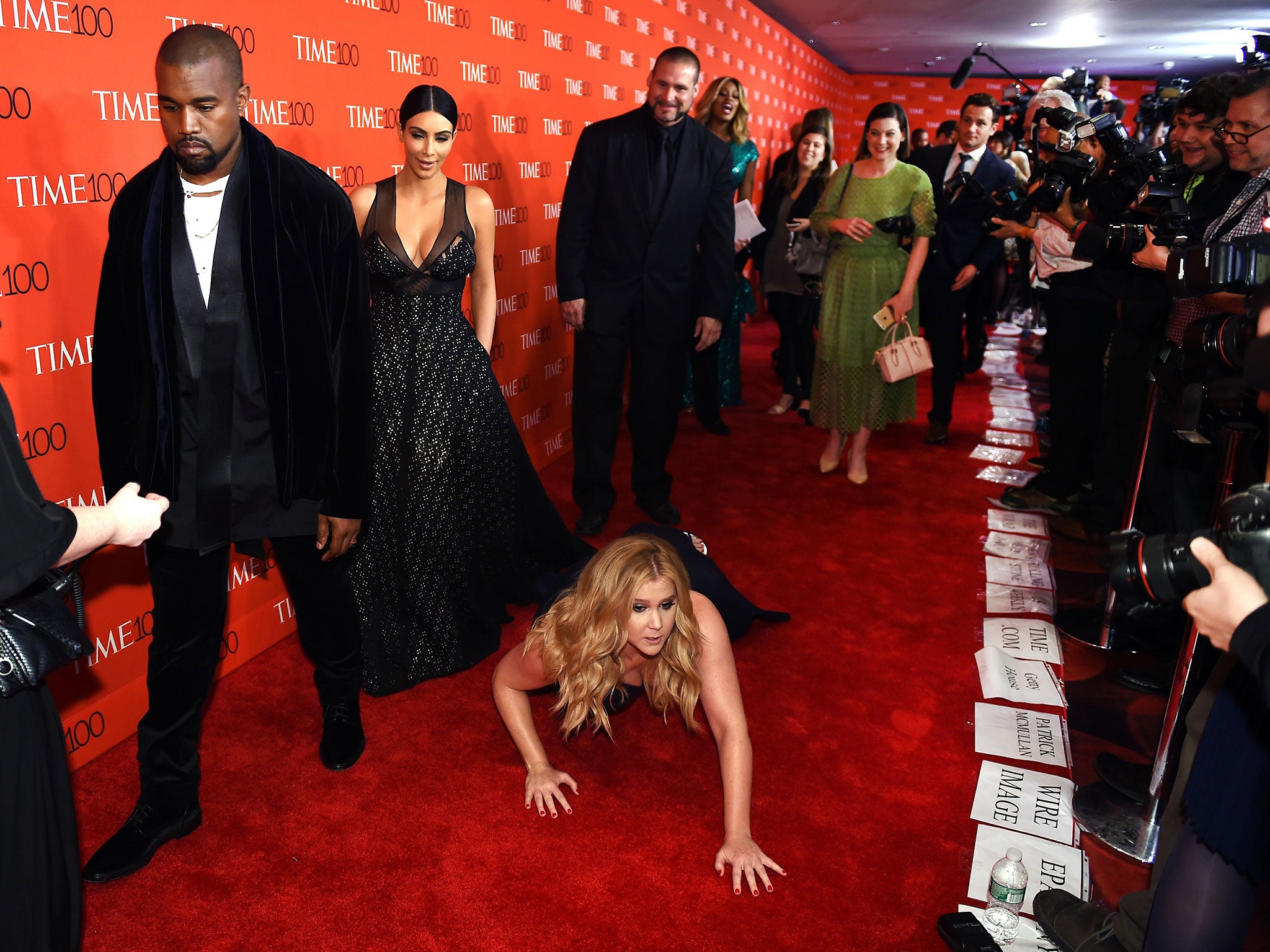 Honoree and Comedian Amy Schumer pretends to trip and fall on the floor in front of honorees Kim Kardashian and Kanye West as they attend the Time 100 Gala celebrating the Time 100 issue of the Most Influential People at The World at Jazz at Lincoln Center in New York