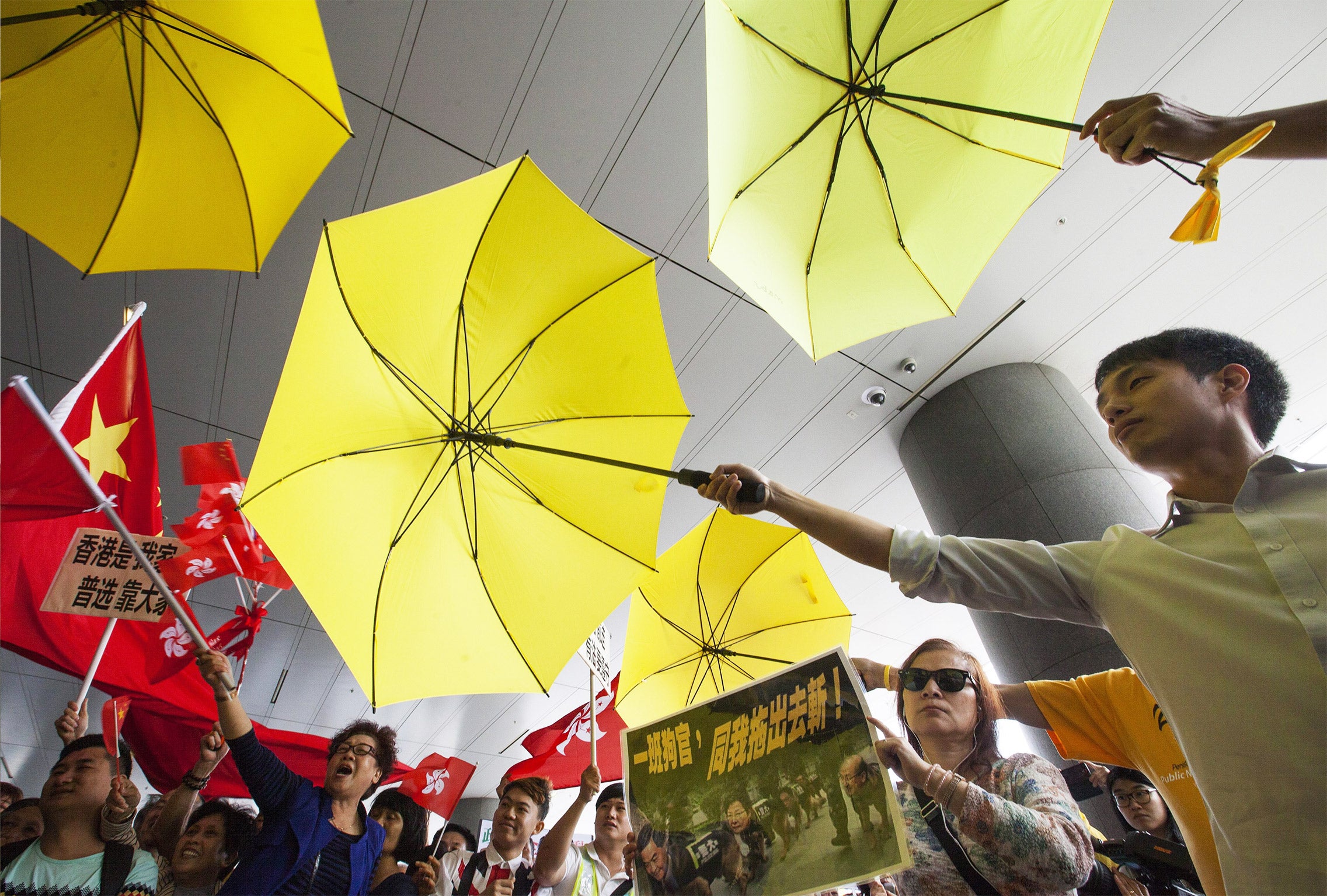 Flag-waving supporters of the reform plans clash with umbrella-wielding pan-democracy campaigners on Wednesday