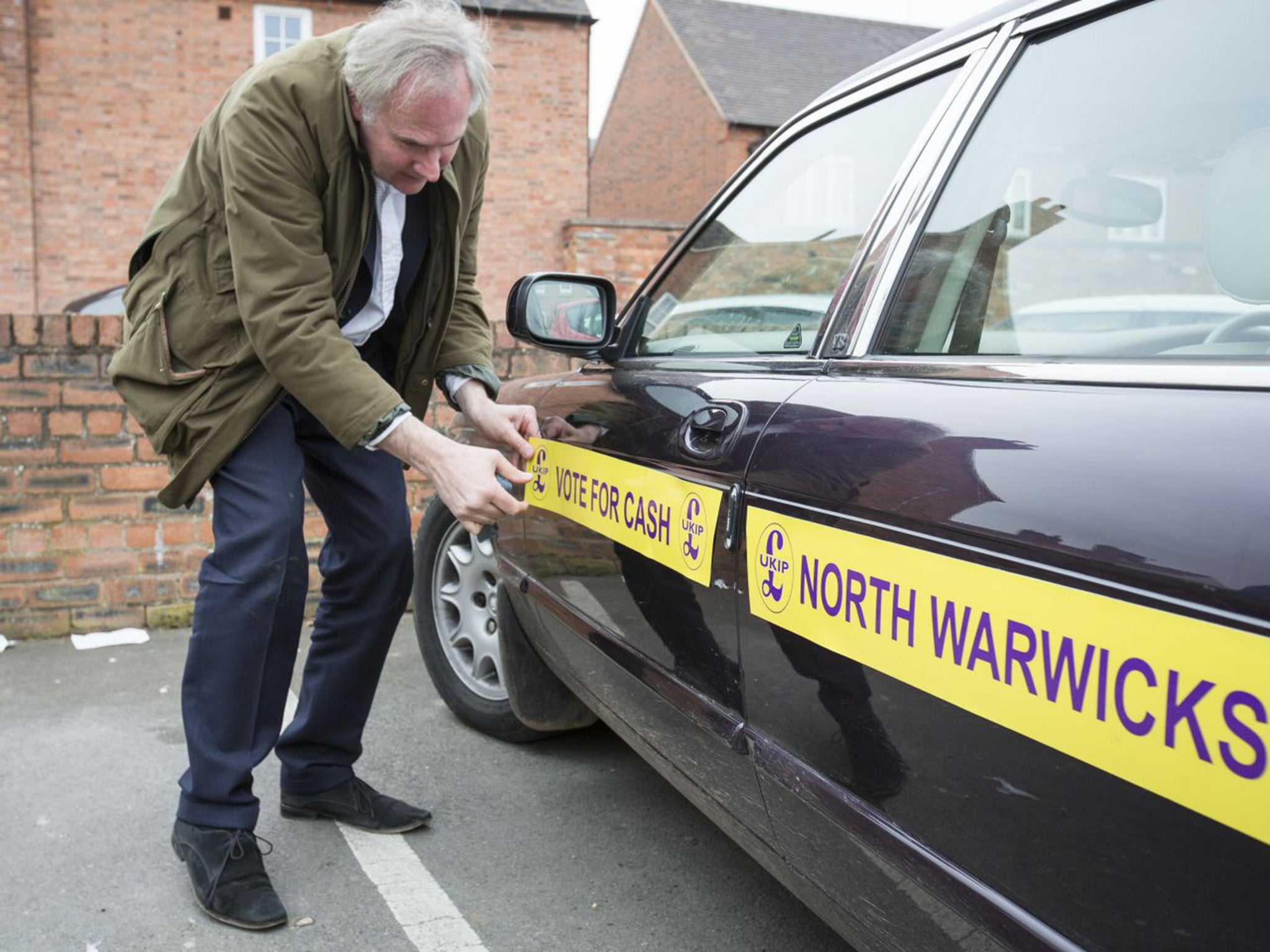 On the money? William Cash, the Ukip candidate for Warwickshire North, decorates his Jaguar before campaigning in Atherstone