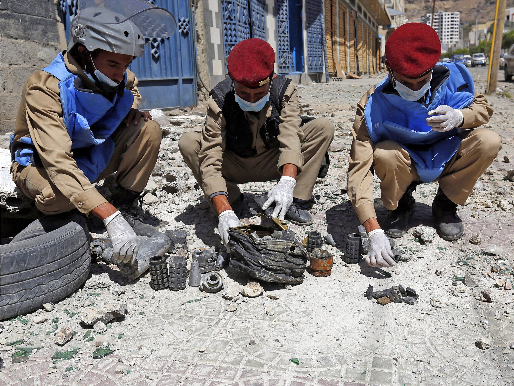 Yemeni soldiers collect mines and explosives at the scene of an airstrike allegedly carried out by the Saudi-led coalition on a nearby Houthi-controlled missile depot in Sanaa