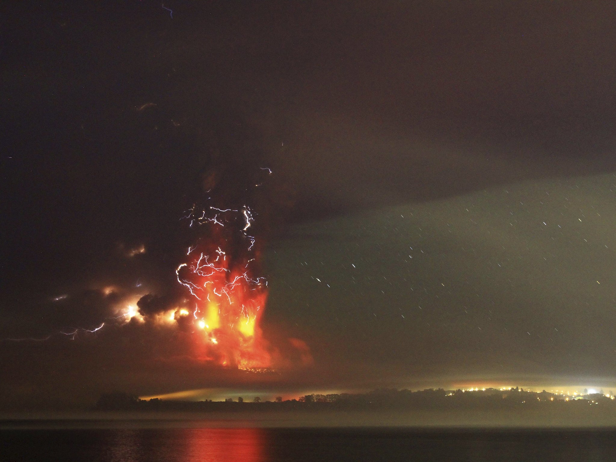 Smoke and lava spew from the Calbuco volcano, as seen from the shores of Lake Llanquihue in Puerto Varas