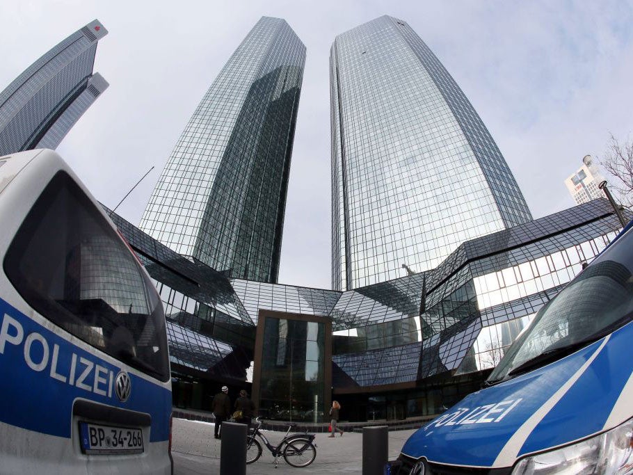 Police cars in front of the head office of Deutsche Bank during an unrelated raid in Frankfurt am Main, Germany