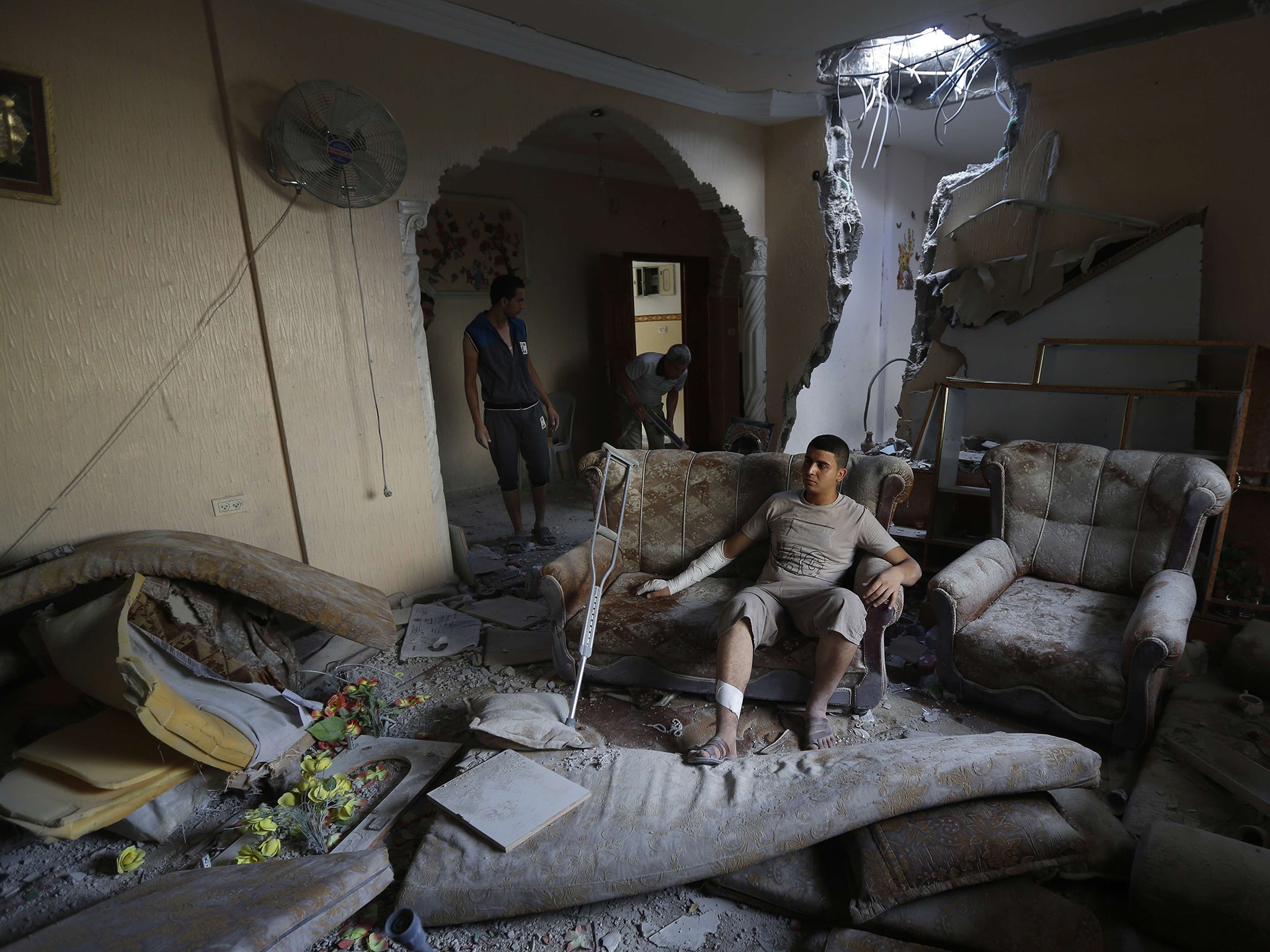 An injured Palestinian man after his house was hit by an Israeli air strike in August 2014