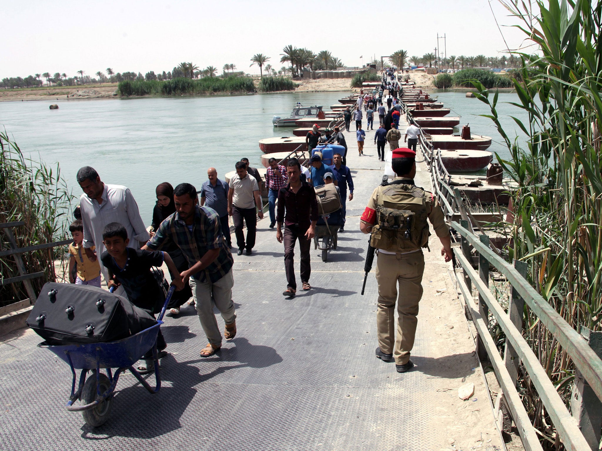 Displaced Iraqis who were forced to flee their hometown ahead of gains made by Islamic State (IS) militants in Ramadi city western Iraqi, cross the Bzebiz bridge on the Euphrates River on their way to Baghdad