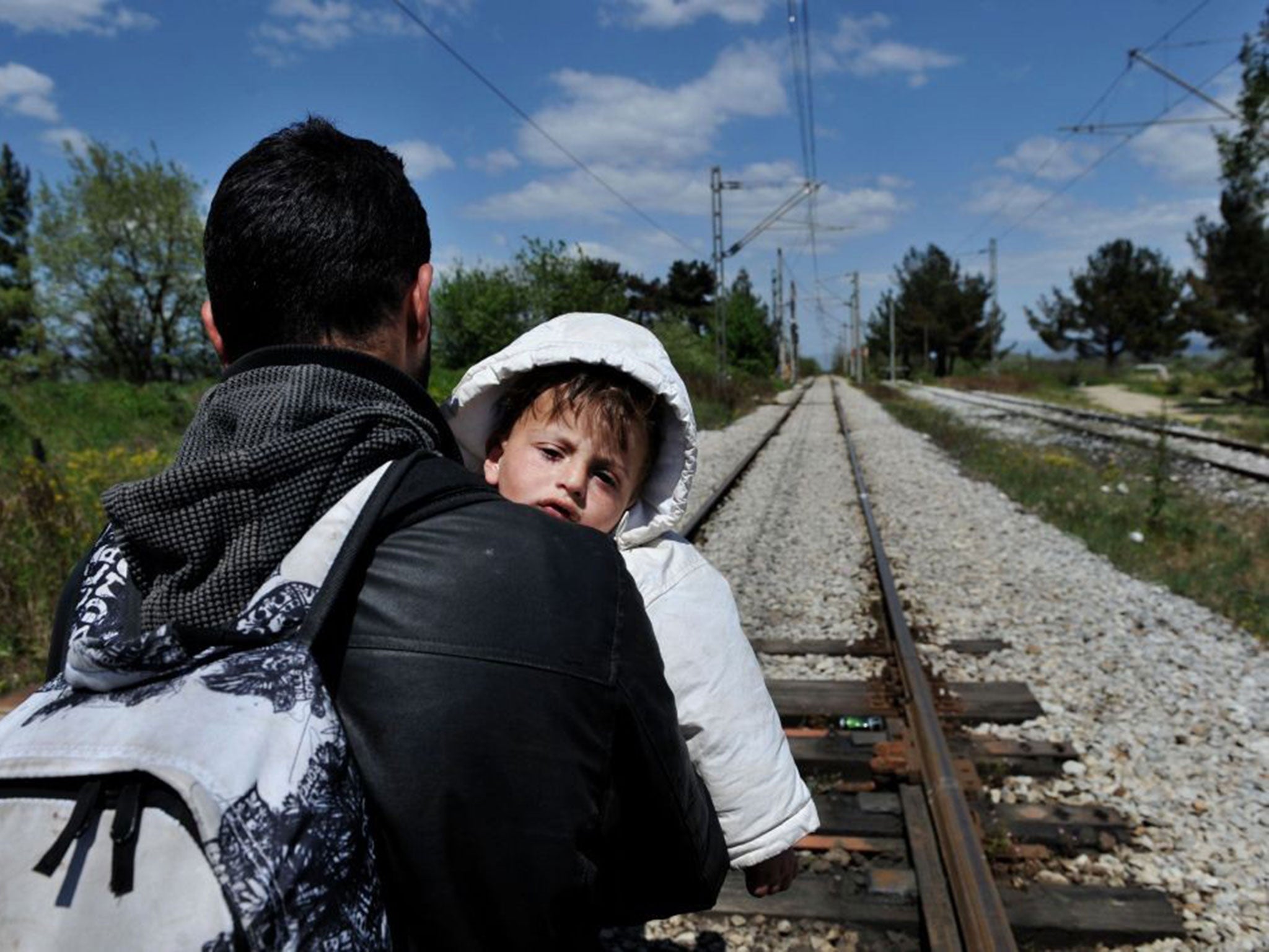 Migrants travelling through Macedonia, seen here near the border with Greece, often use railway lines