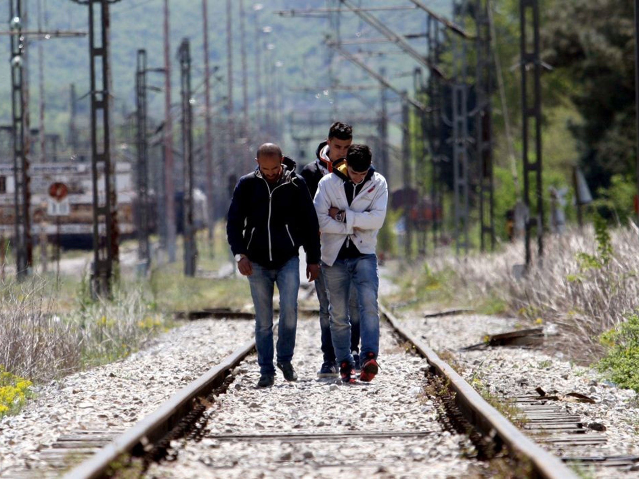 Migrants from Syria cross the railways at the border post of Idomeni at the Greece-Macedonia border on April 21