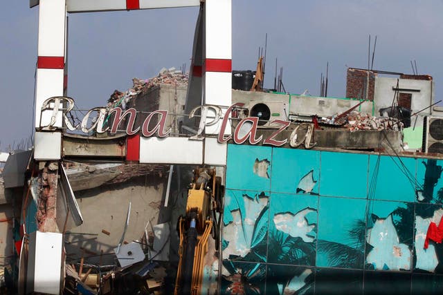 A signboard outside the factory reads “Rana Plaza” as it collapses on 24 April 2013 