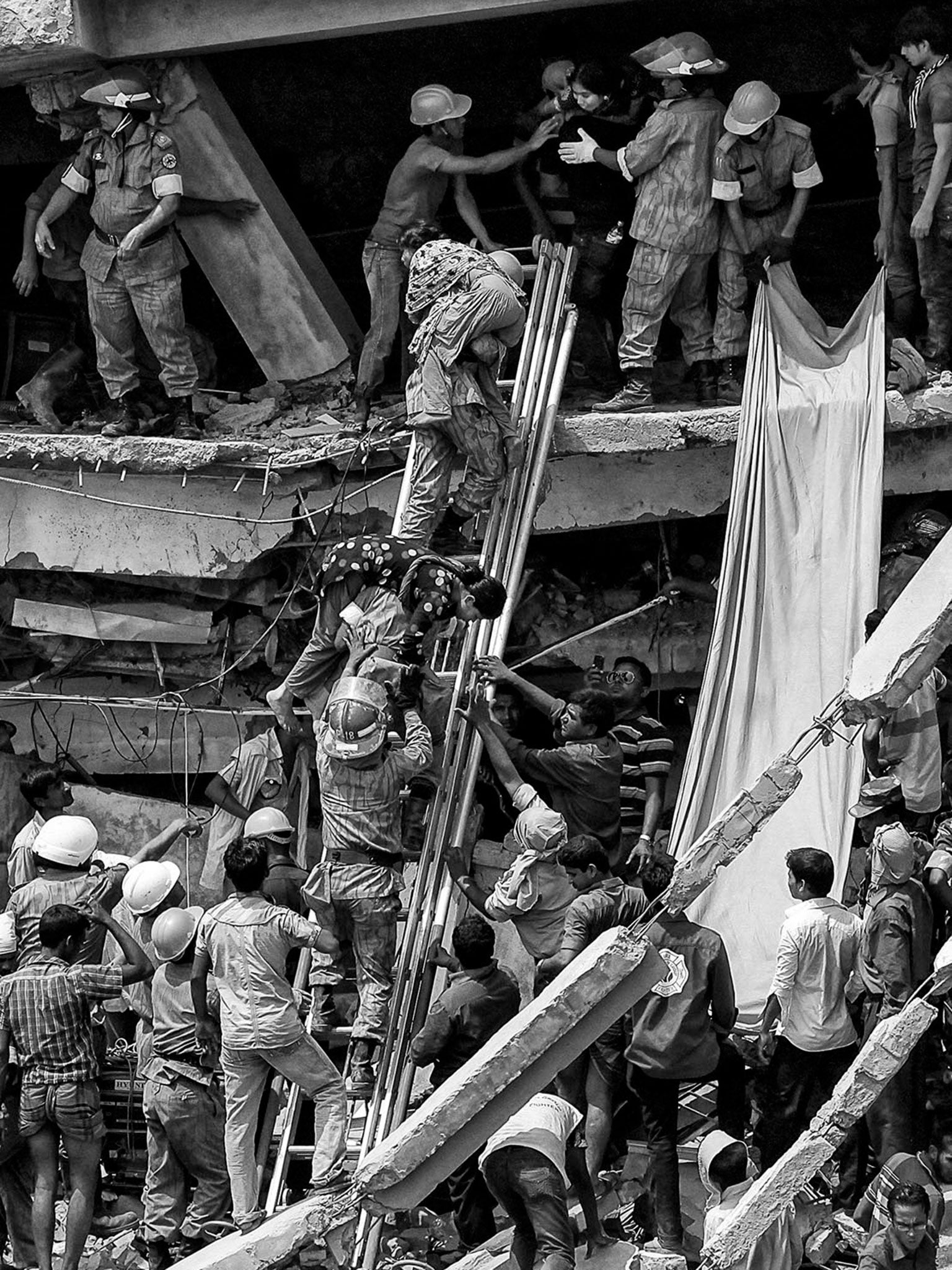 Rescuers pull out wounded workers of the wrecked eight-storey factory building that caves in on the outskirts of Bangladesh capital Dhaka on 24 April 2013 © Monirul Alam